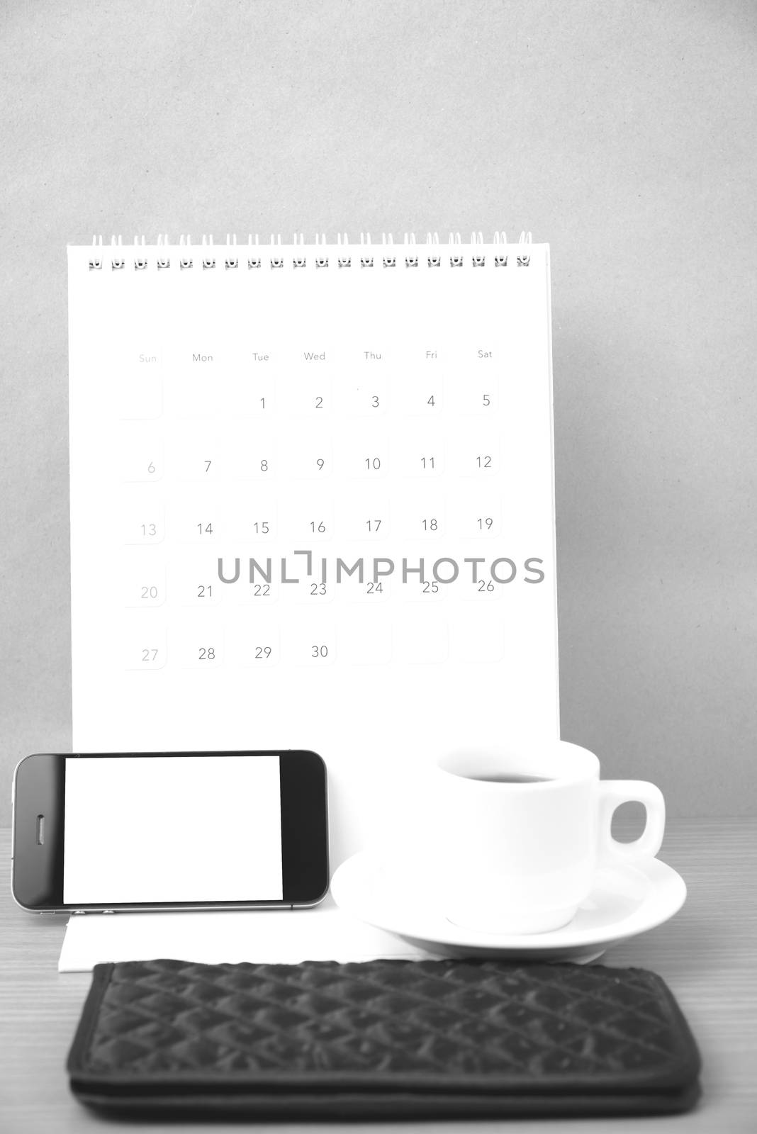 coffee,phone,wallet and canlendar on wood table background black and white color