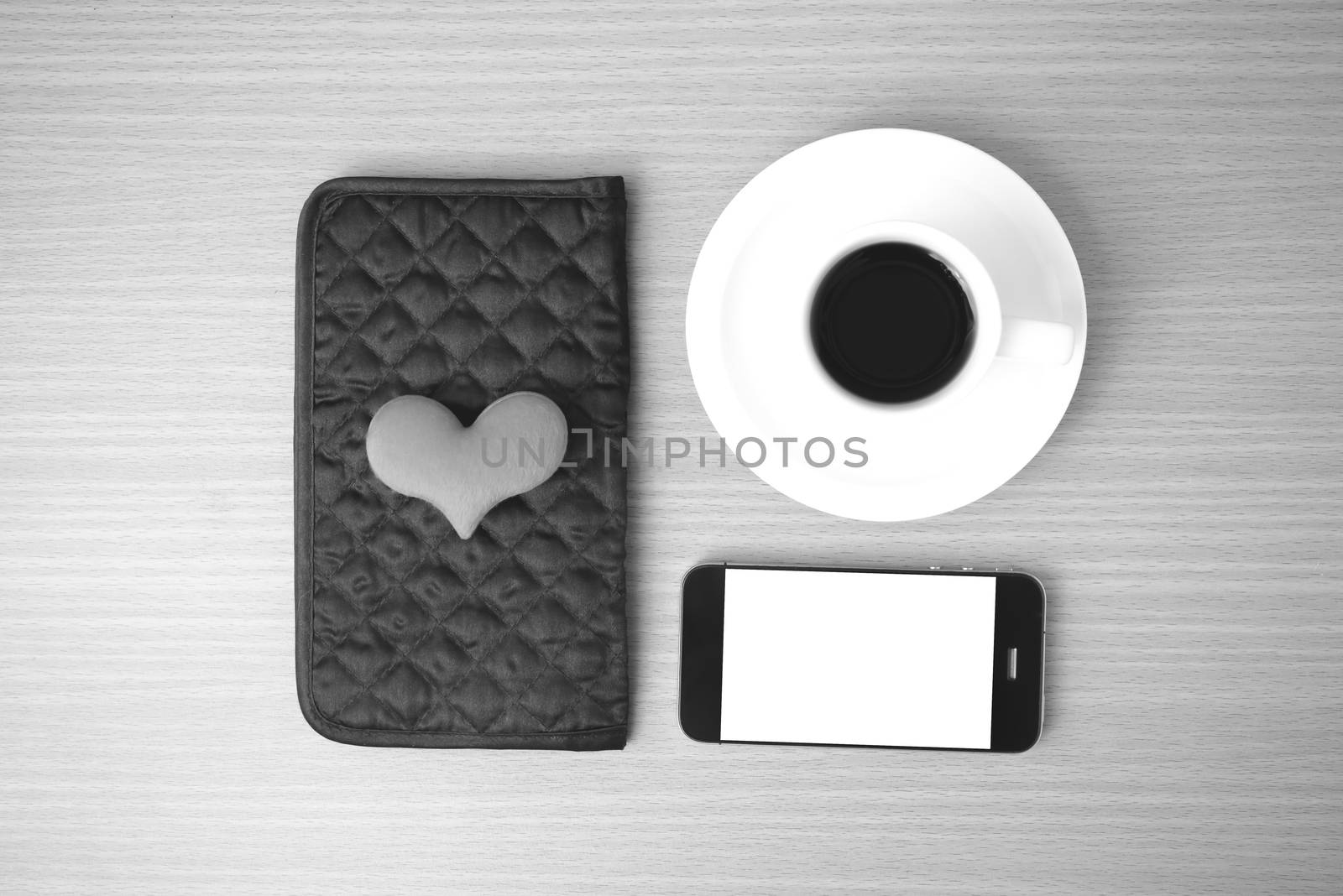 coffee,phone,wallet and heart on wood table background black and white color