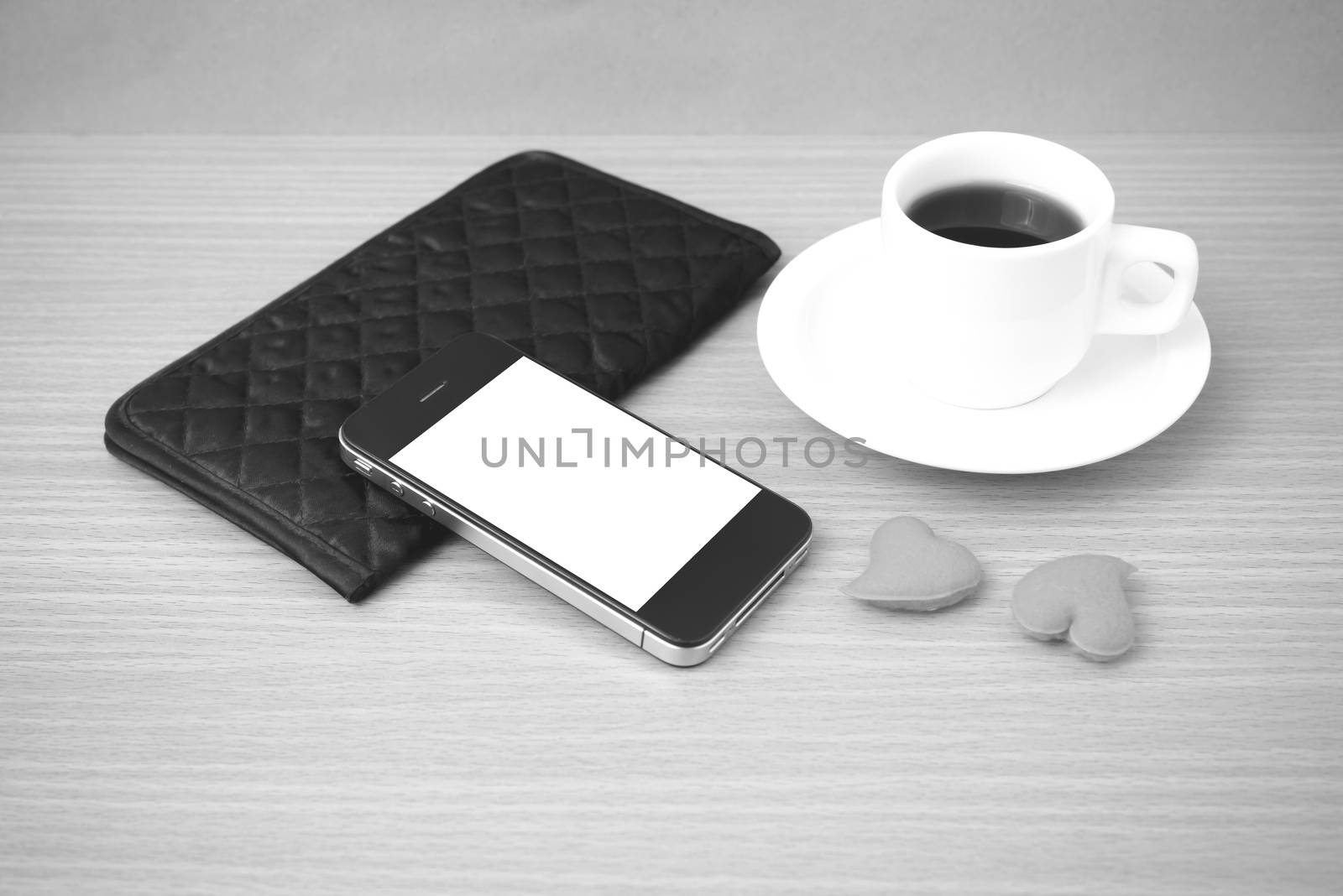 coffee,phone,wallet and heart on wood table background black and white color