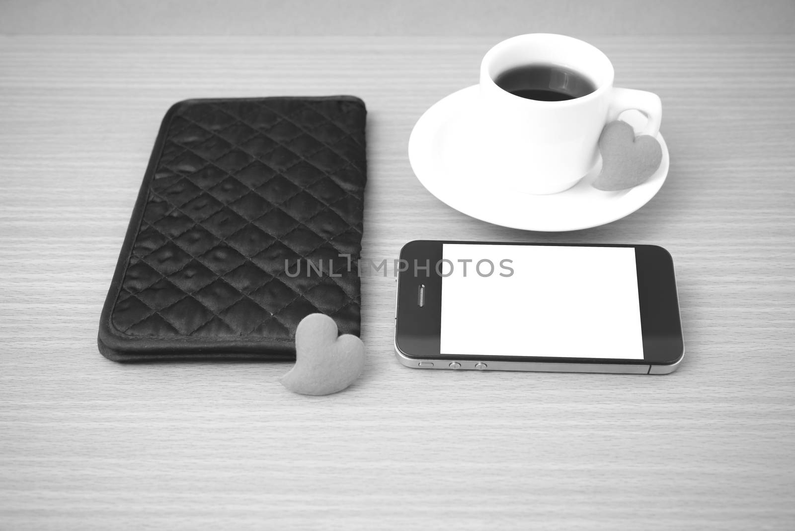 coffee,phone,wallet and heart on wood table background black and white color