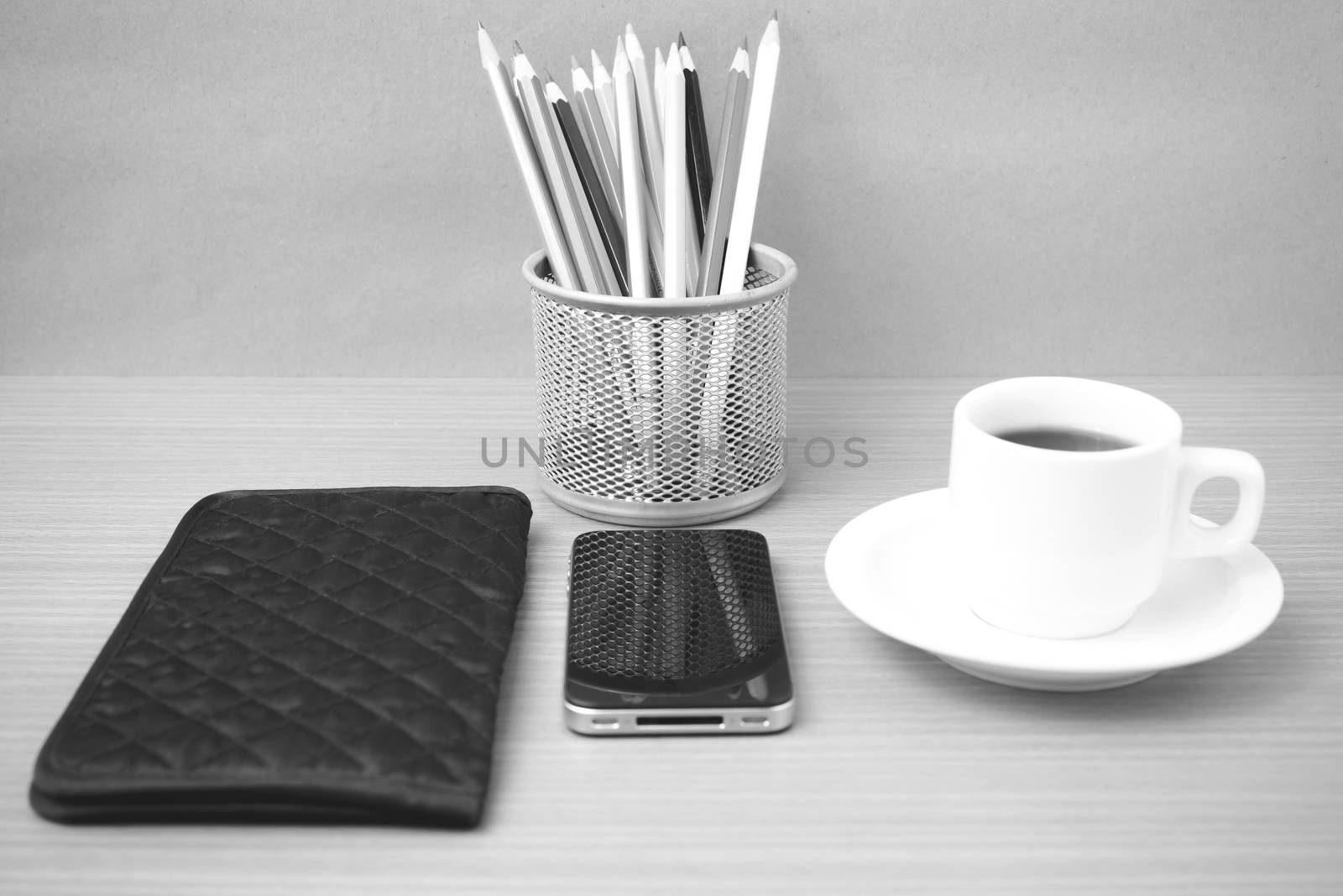 coffee,phone,wallet and color pencil on wood table background black and white color