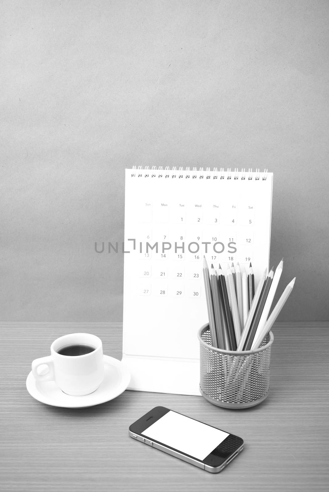 coffee,phone,calendar and color pencil on wood table background black and white color