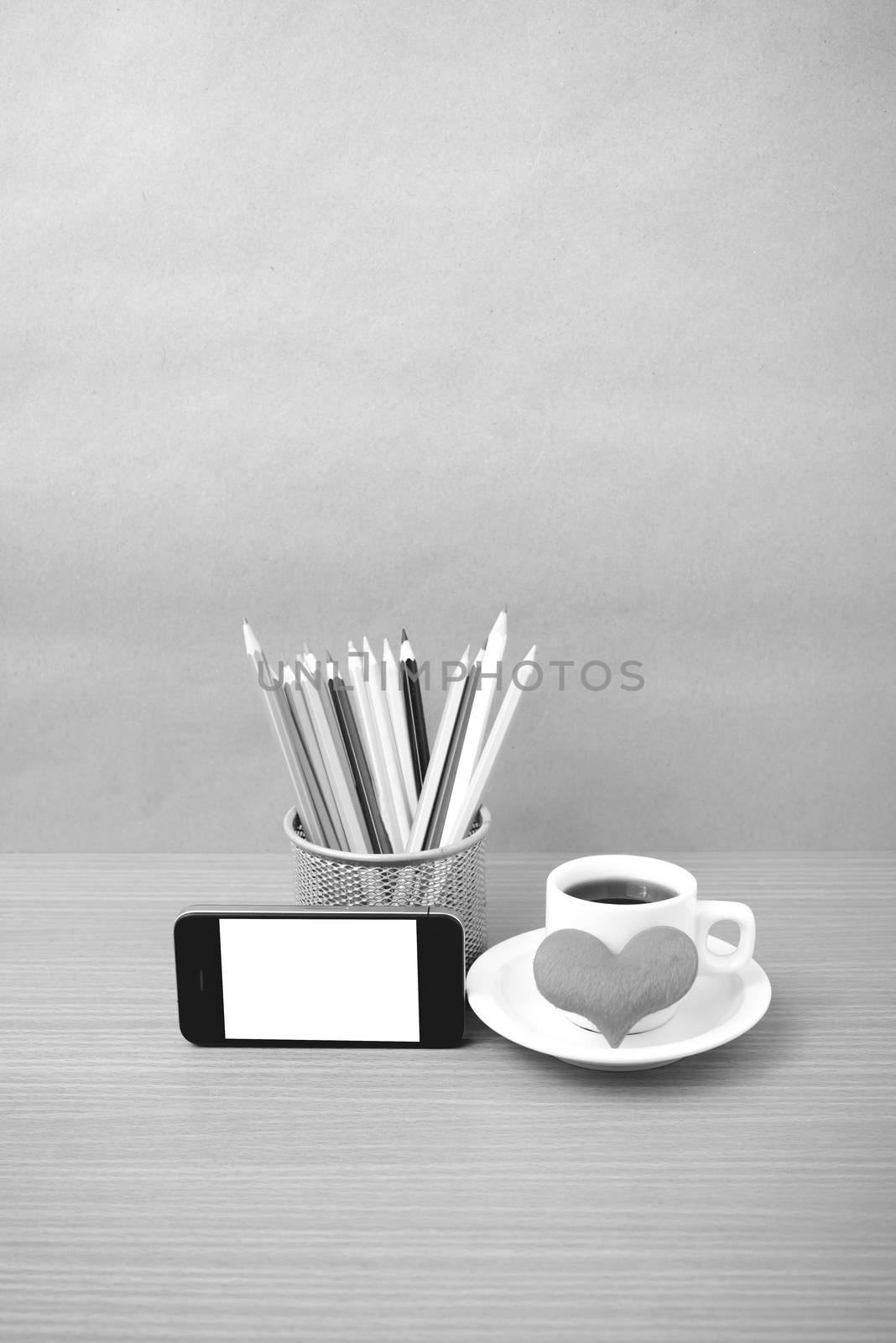 coffee,phone,color pencil and heart on wood table background black and white color