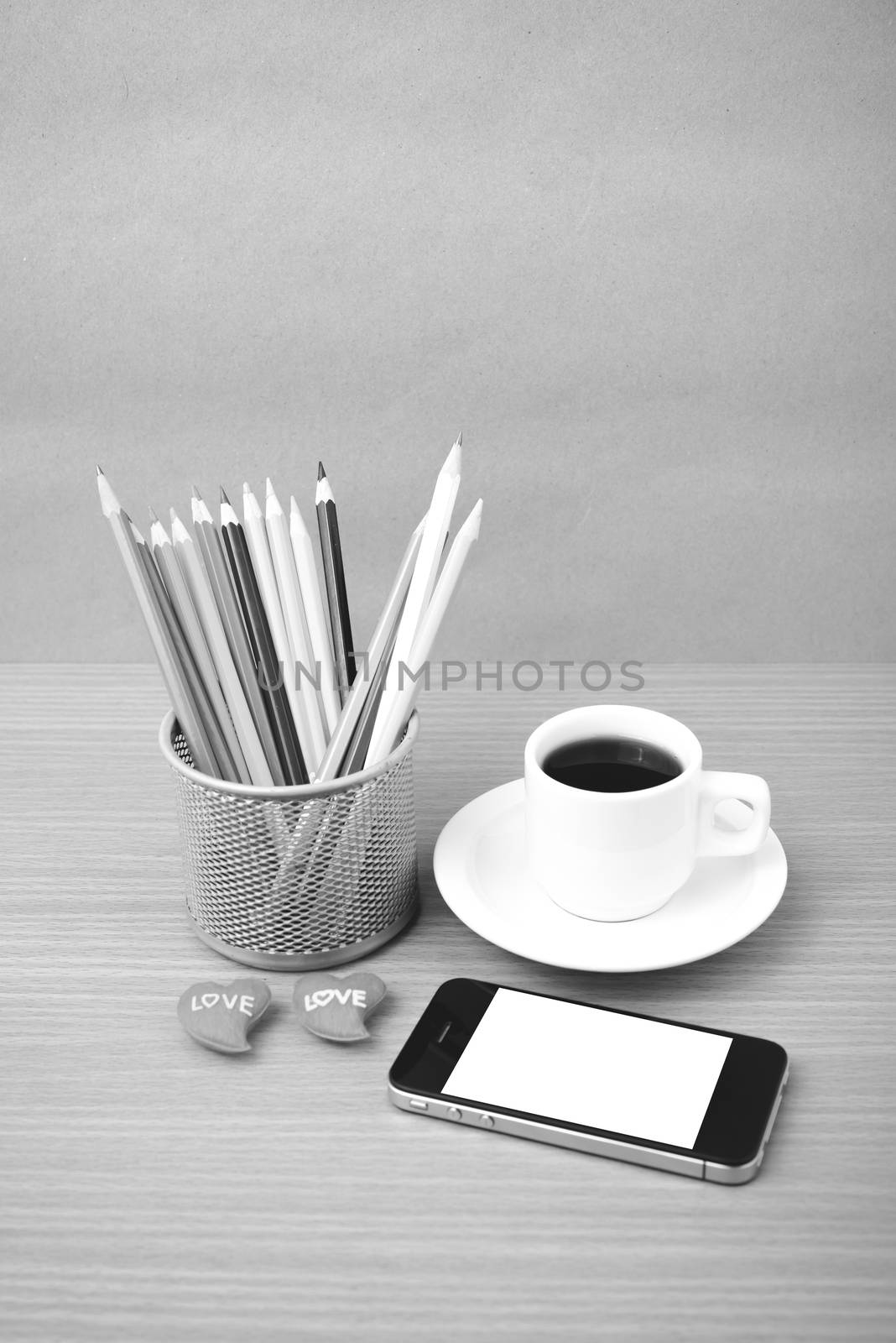 coffee,phone,color pencil and heart on wood table background black and white color