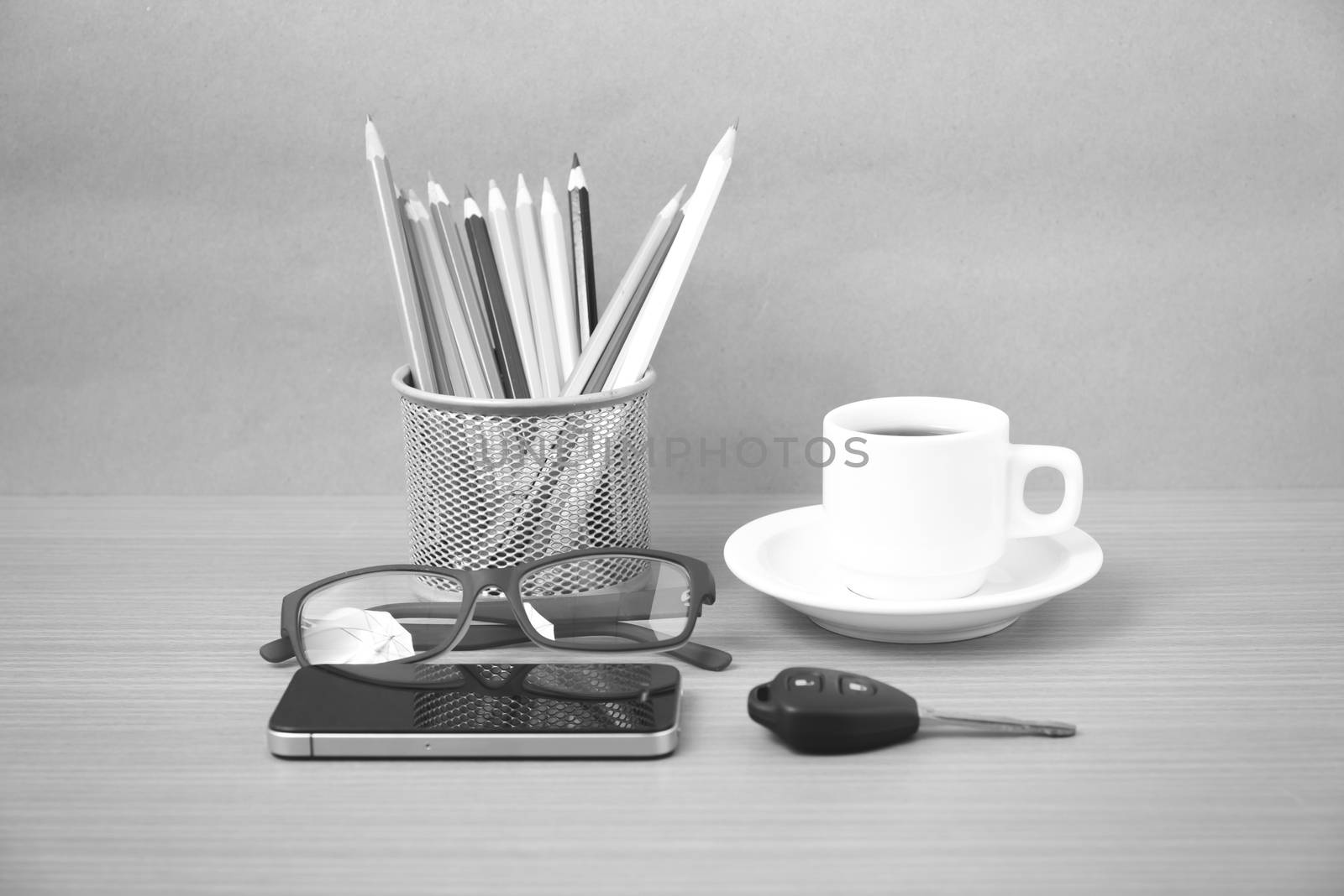 coffee,phone,eyeglasses,color pencil and car key on wood table background black and white color