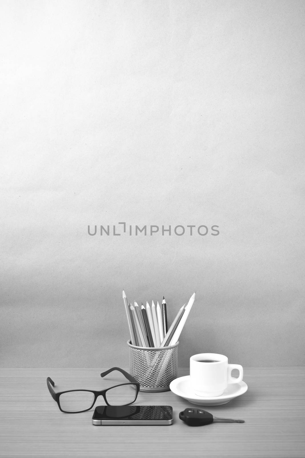 coffee,phone,eyeglasses,color pencil and car key on wood table background black and white color