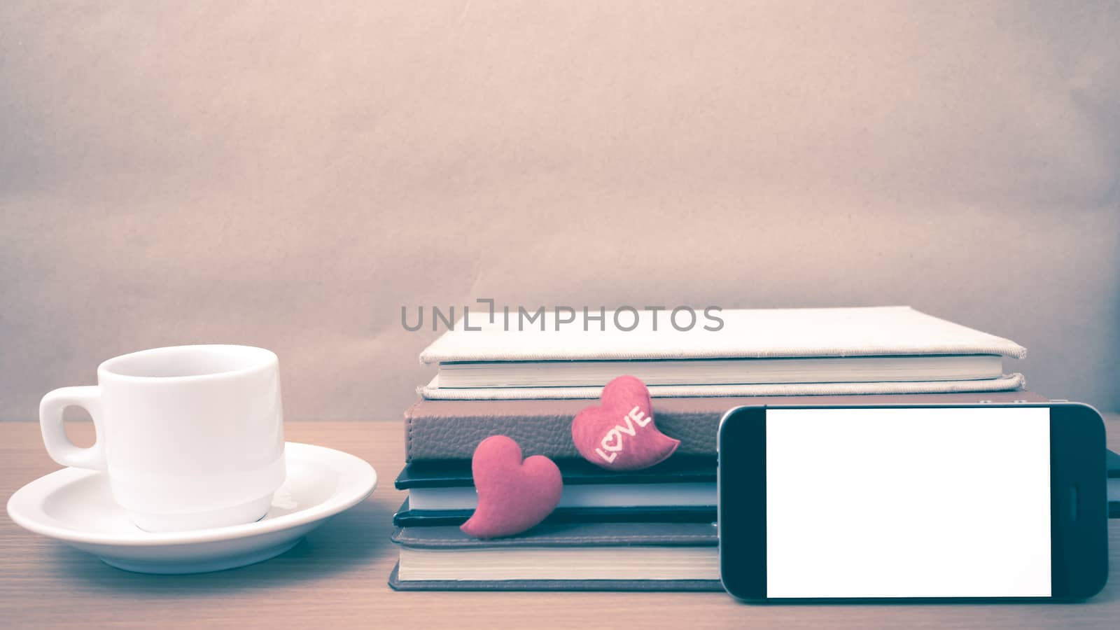 coffee,phone,stack of book and heart on wood table background vintage style
