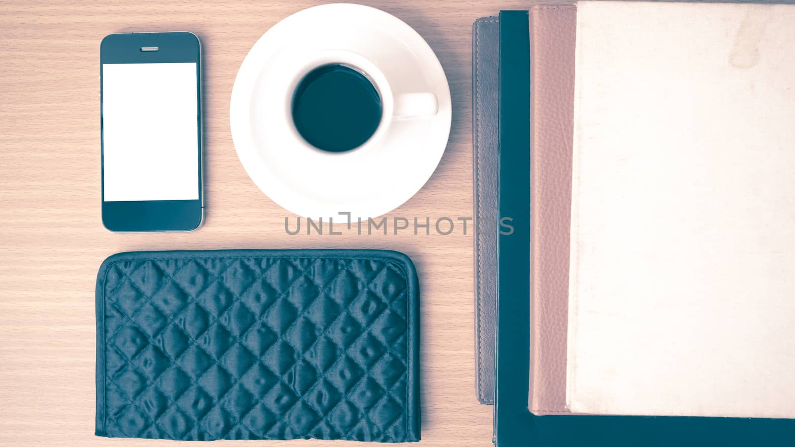 coffee,phone,stack of book and wallet on wood table background vintage style