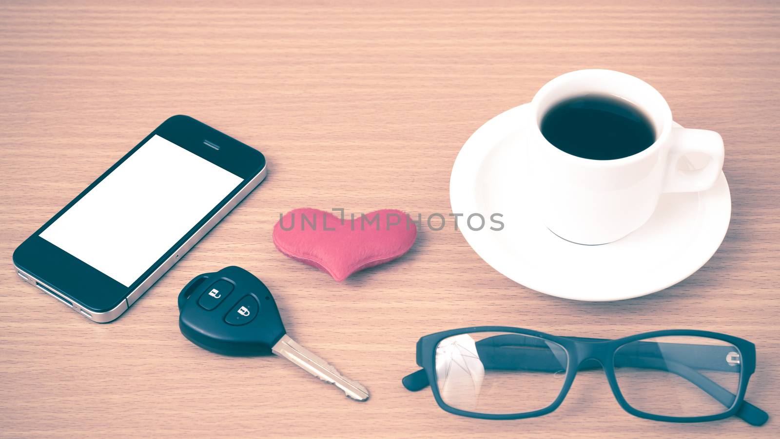 coffee,phone,eyeglasses and car key on wood table background vintage style