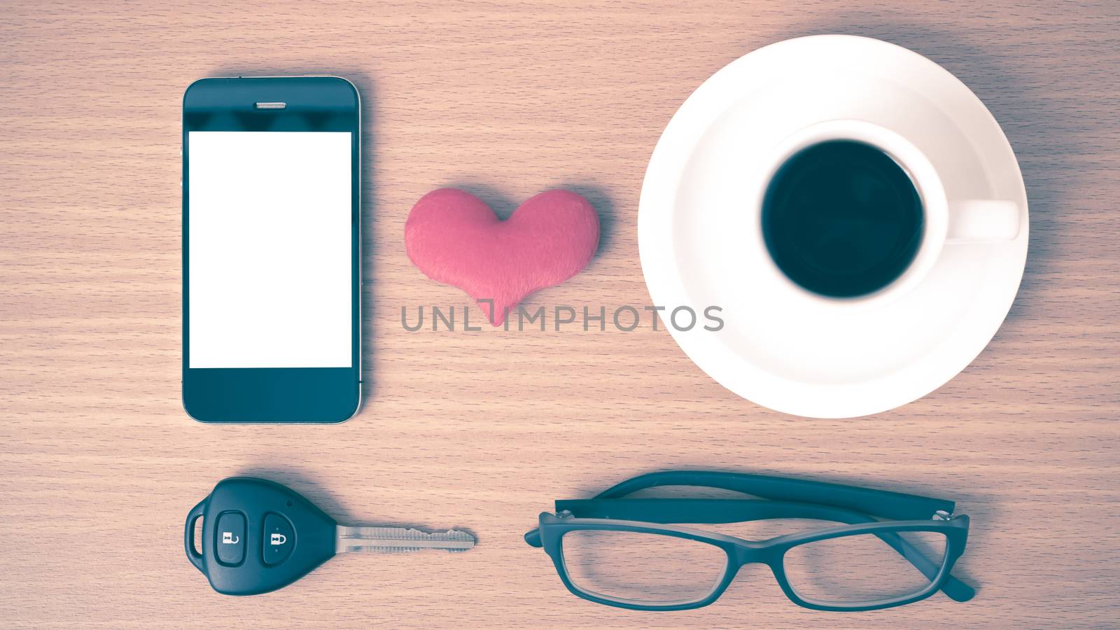 coffee,phone,eyeglasses and car key on wood table background vintage style