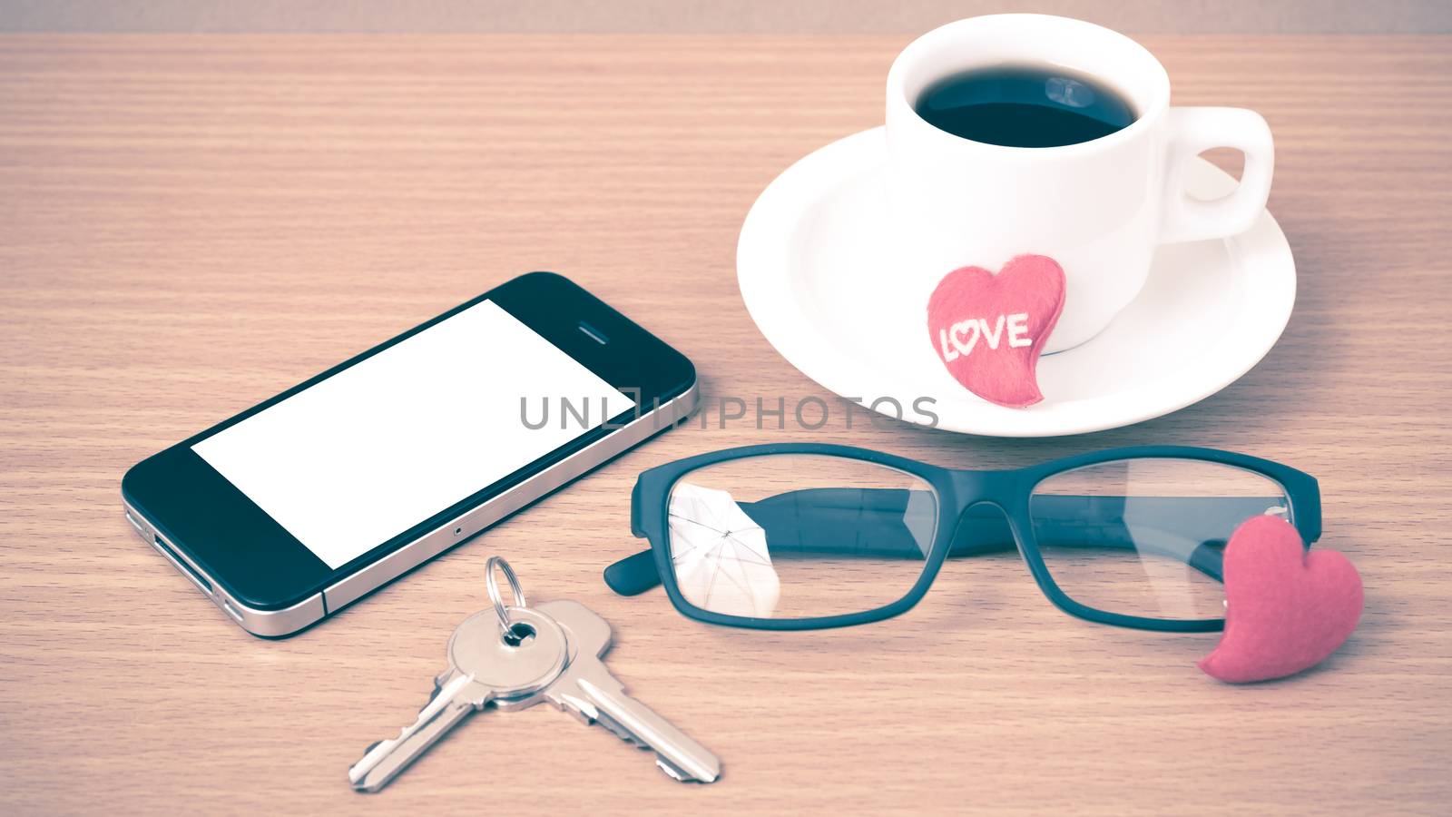 coffee,phone,eyeglasses and key on wood table background vintage style