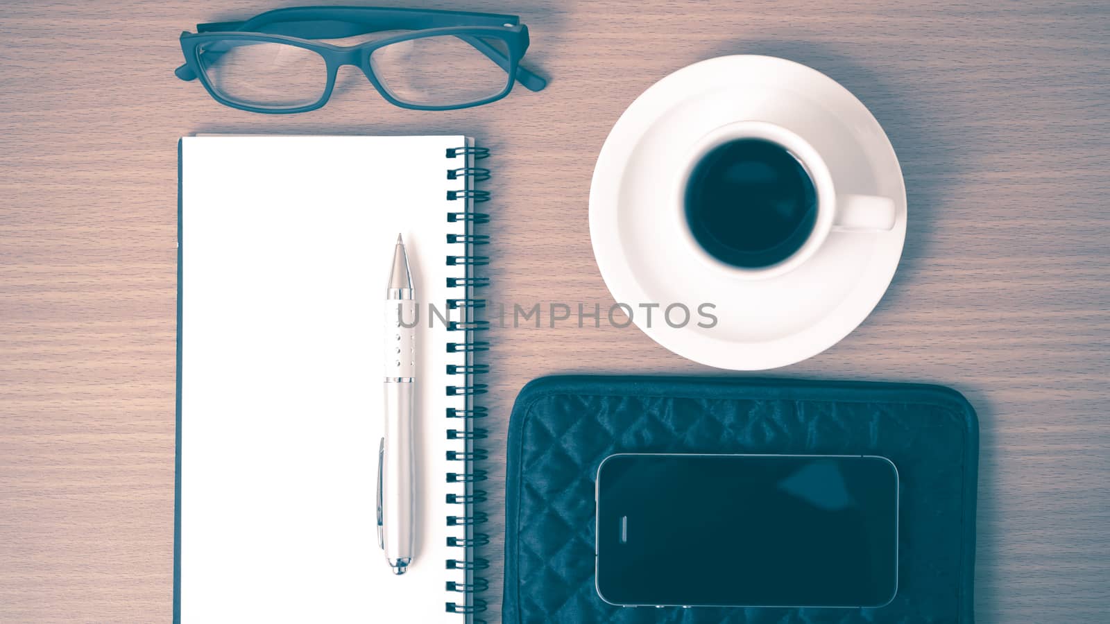 coffee,phone,eyeglasses,notepad and wallet on wood table background vintage style