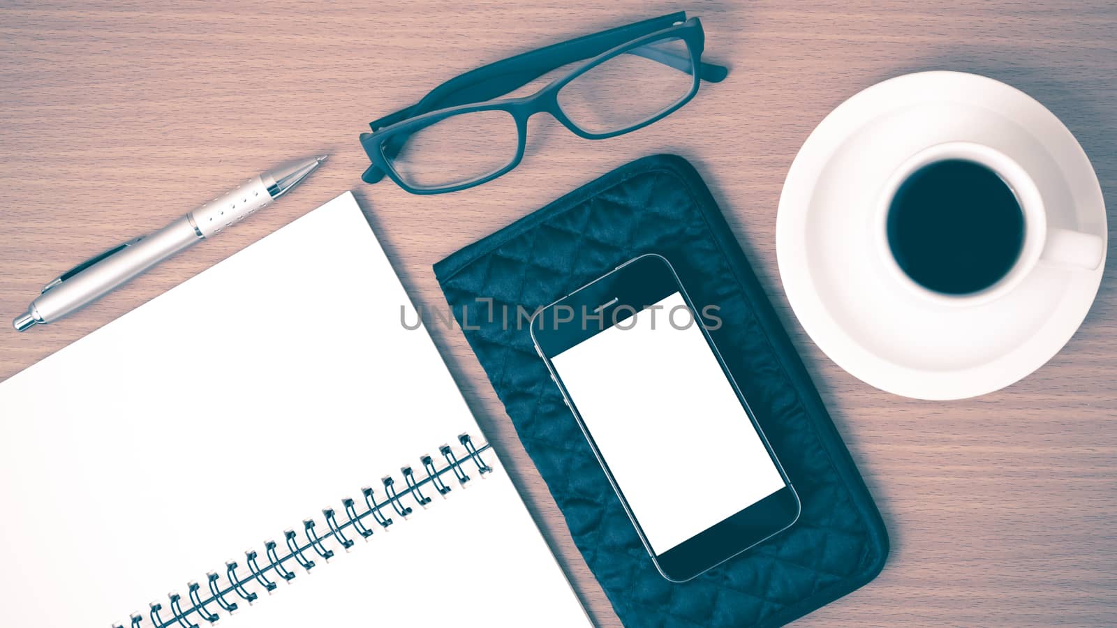 coffee,phone,eyeglasses,notepad and wallet on wood table background vintage style