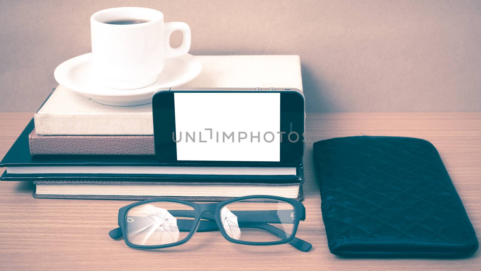 coffee,phone,eyeglasses,stack of book and wallet on wood table background vintage style