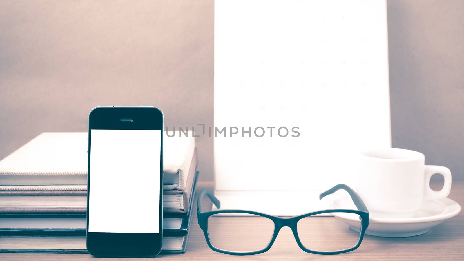 coffee,phone,eyeglasses,stack of book and calendar on wood table background vintage style