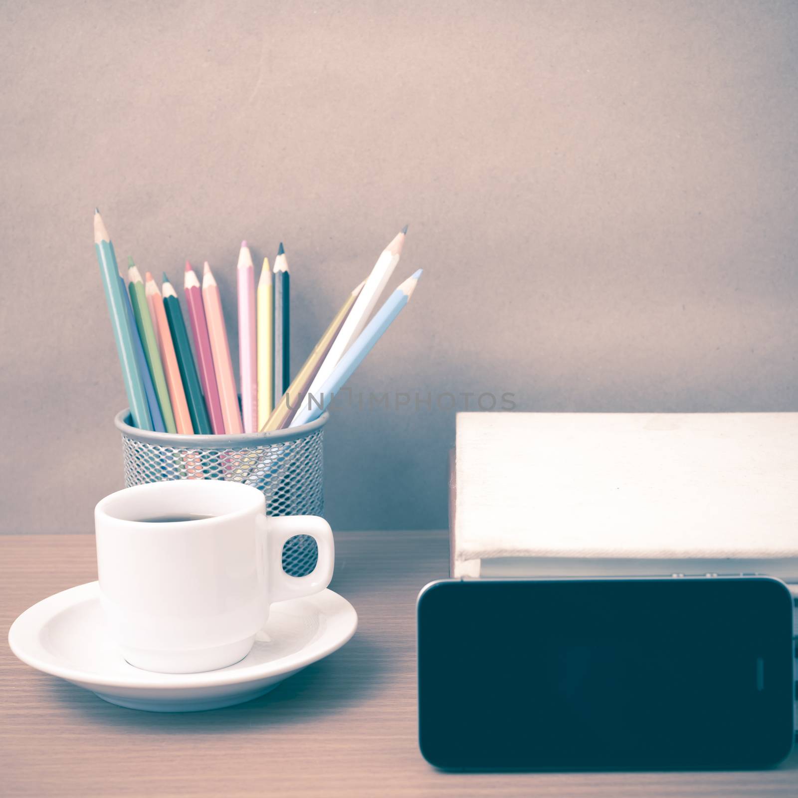 coffee,phone,stack of book and color pencil on wood table background vintage style