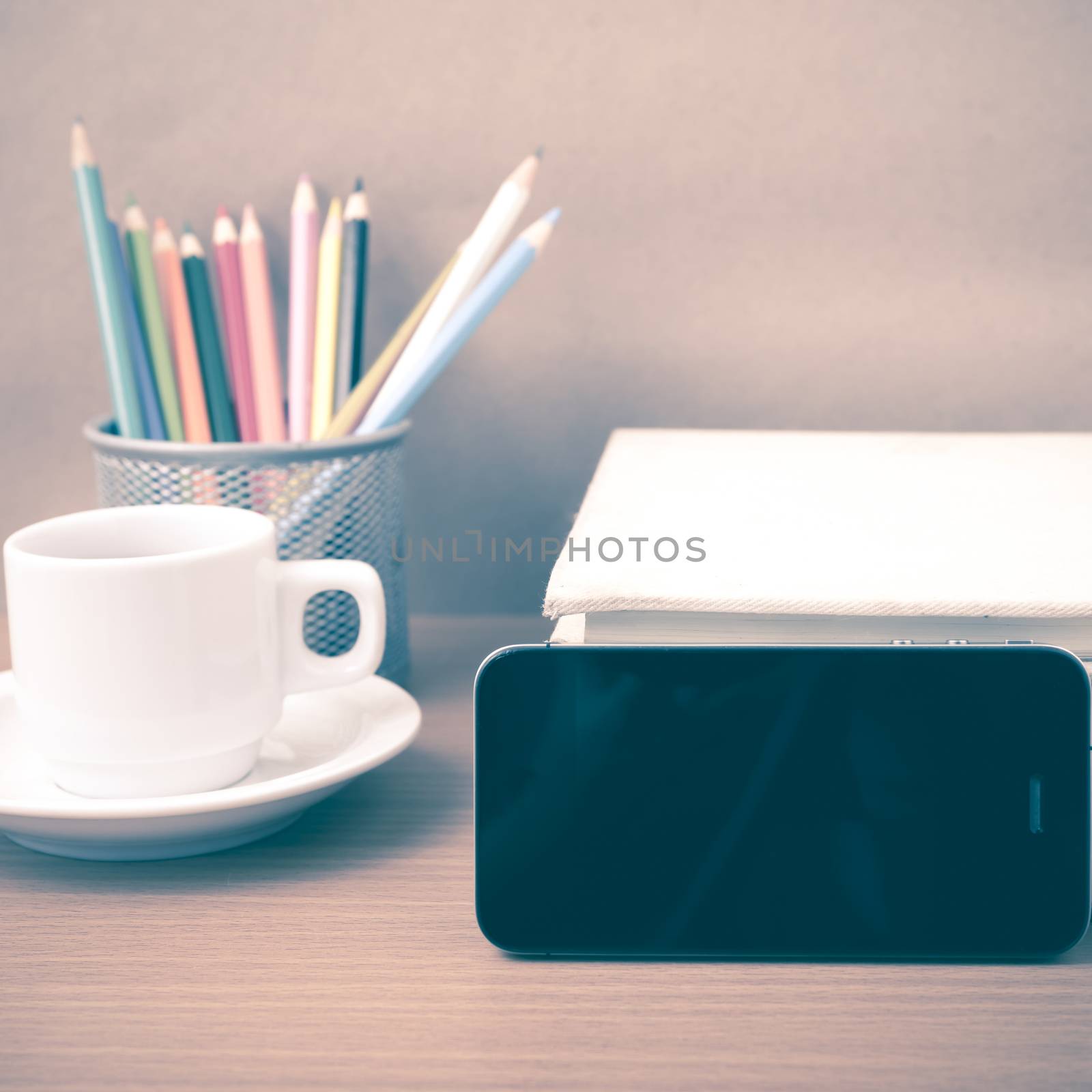 coffee,phone,stack of book and color pencil on wood table background vintage style