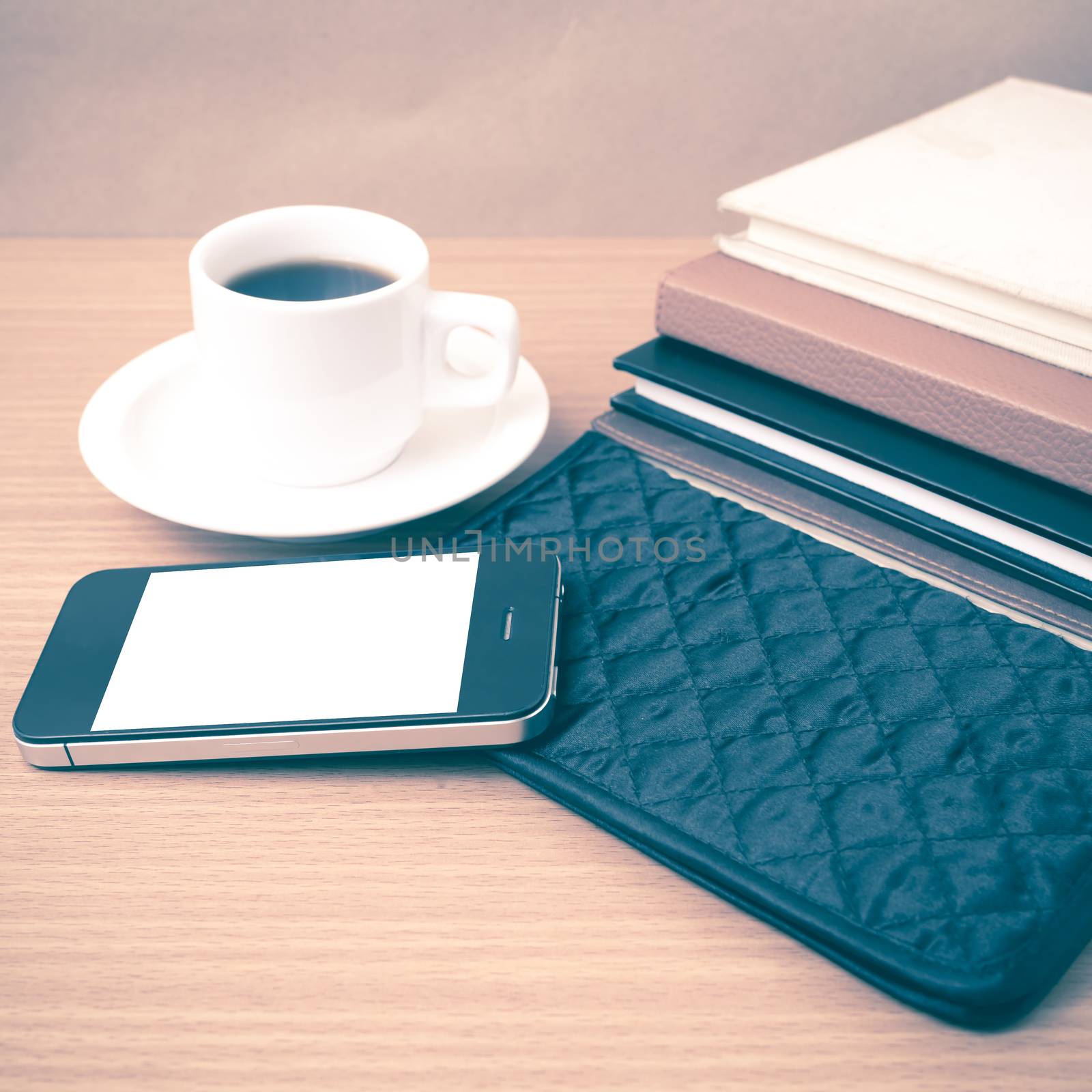 coffee,phone,stack of book and wallet on wood table background vintage style