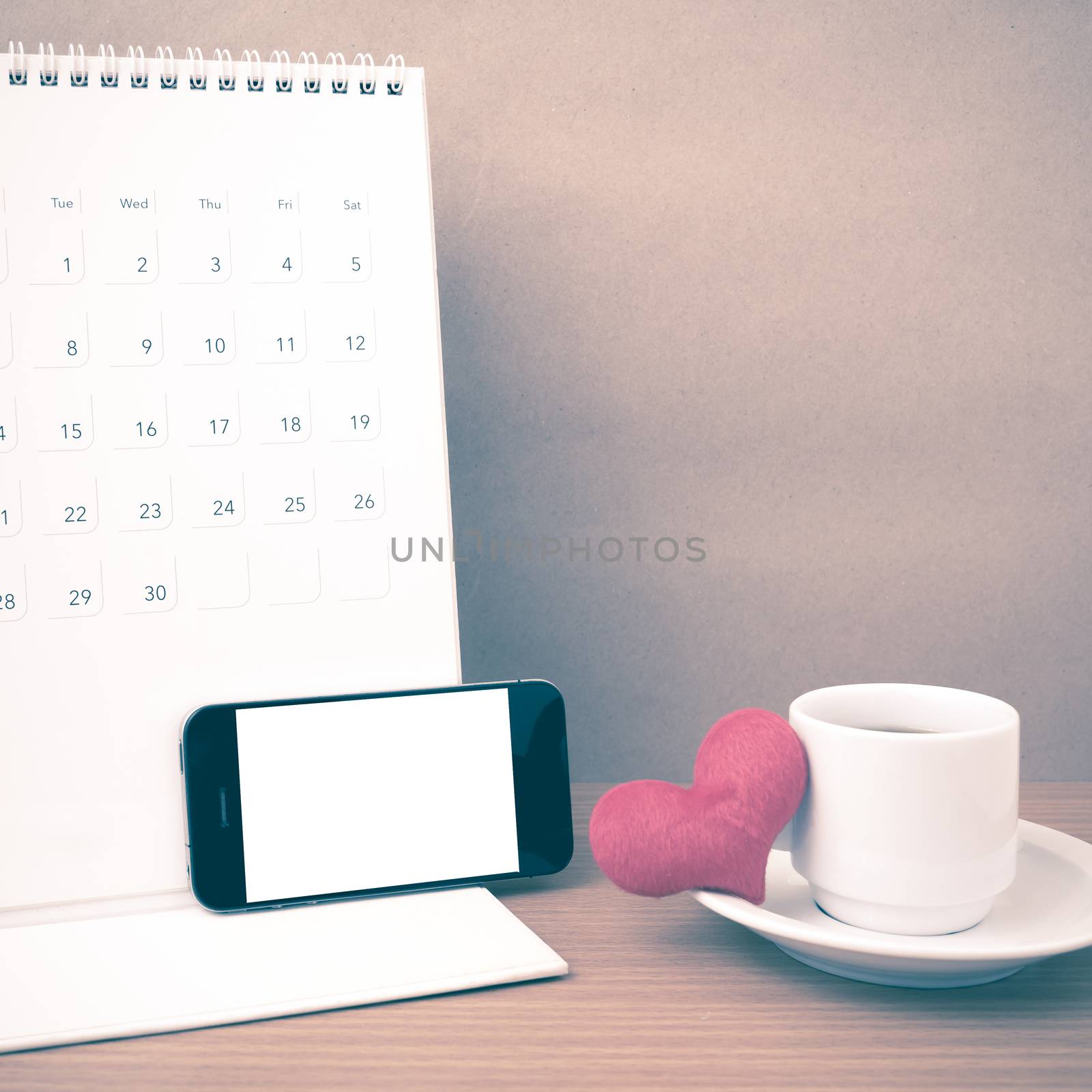 coffee,phone,calendar and heart on wood table background vintage style