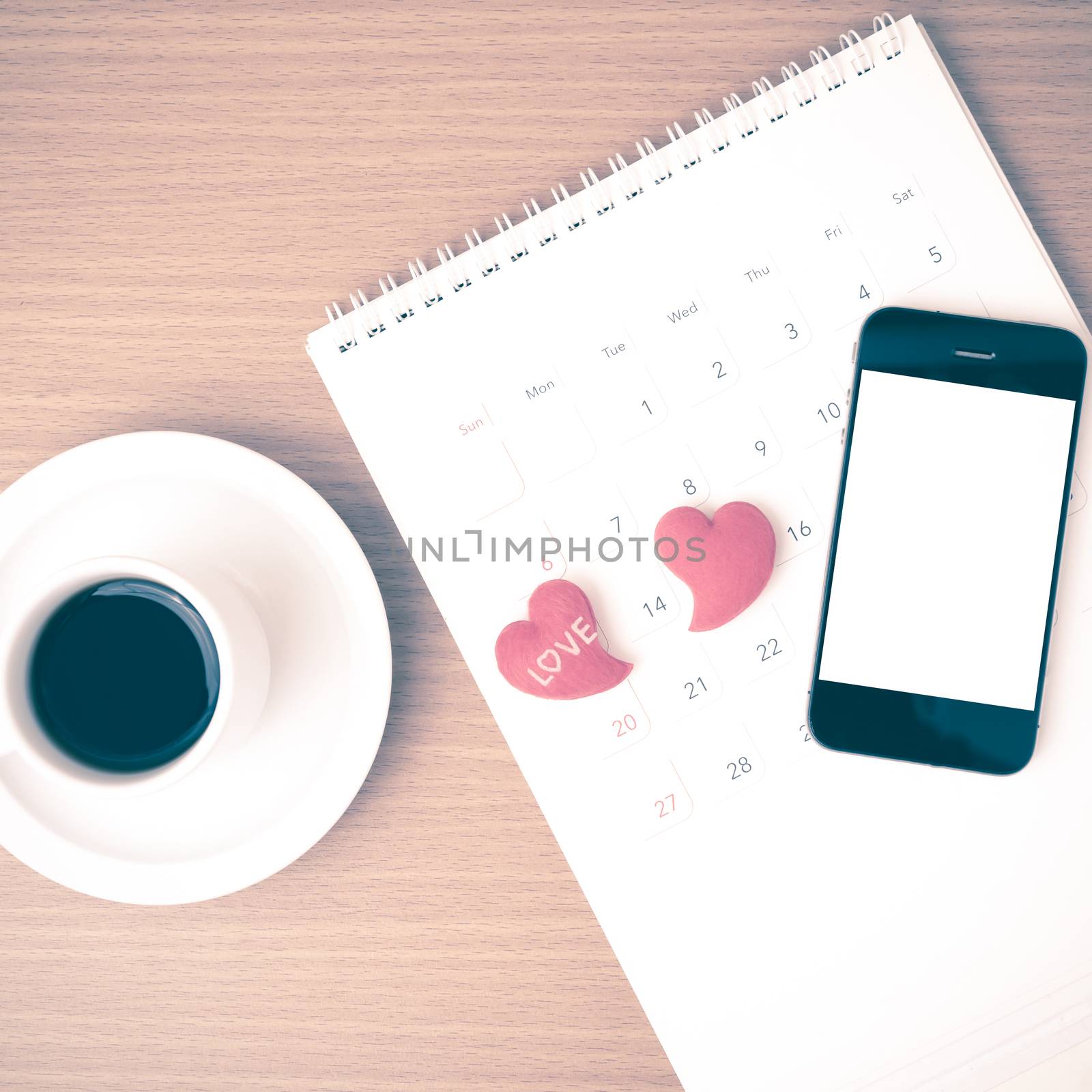 coffee,phone,calendar and heart on wood table background vintage style