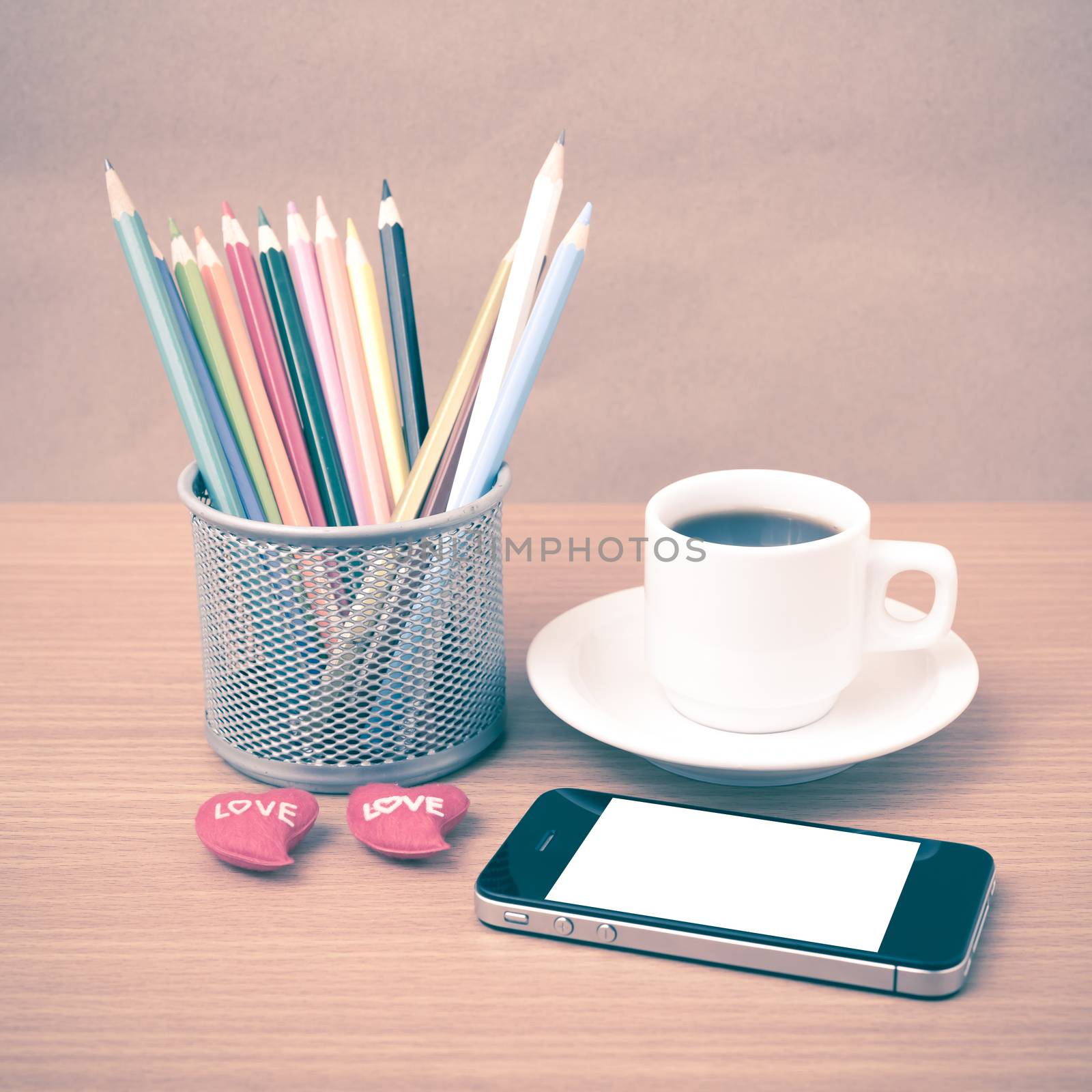 coffee,phone,color pencil and heart on wood table background vintage style
