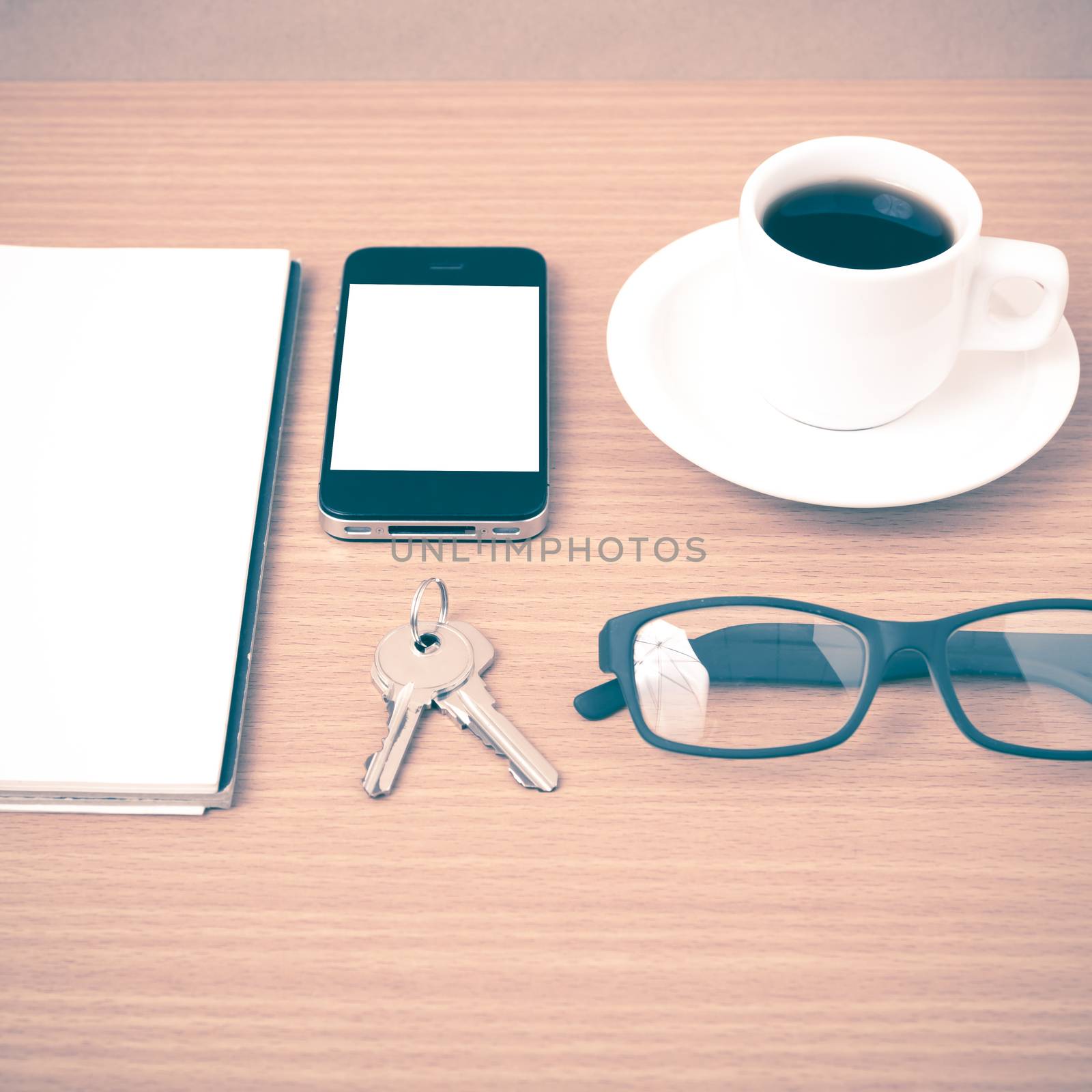 coffee,phone,notepad,eyeglasses and key on wood table background vintage style