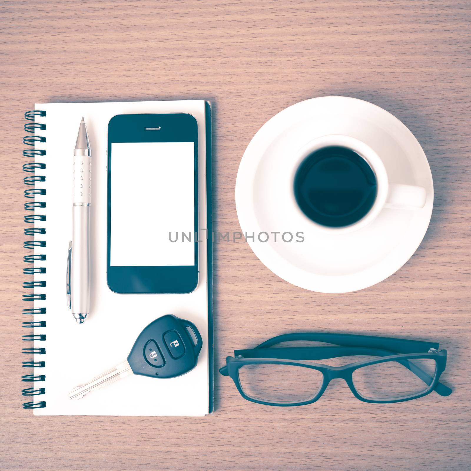 coffee,phone,notepad,eyeglasses and car key on wood table background vintage style
