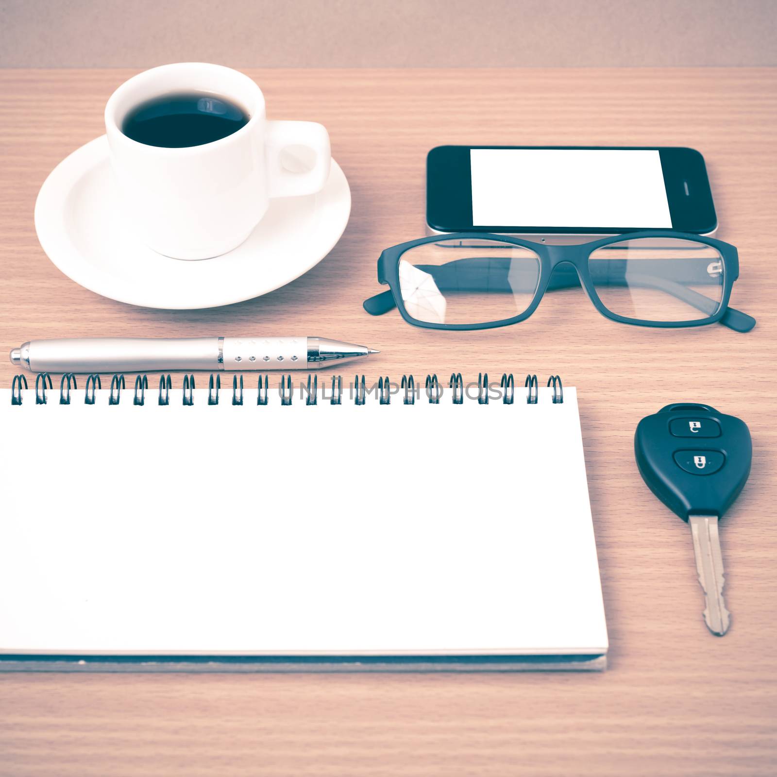 coffee,phone,notepad,eyeglasses and car key on wood table background vintage style