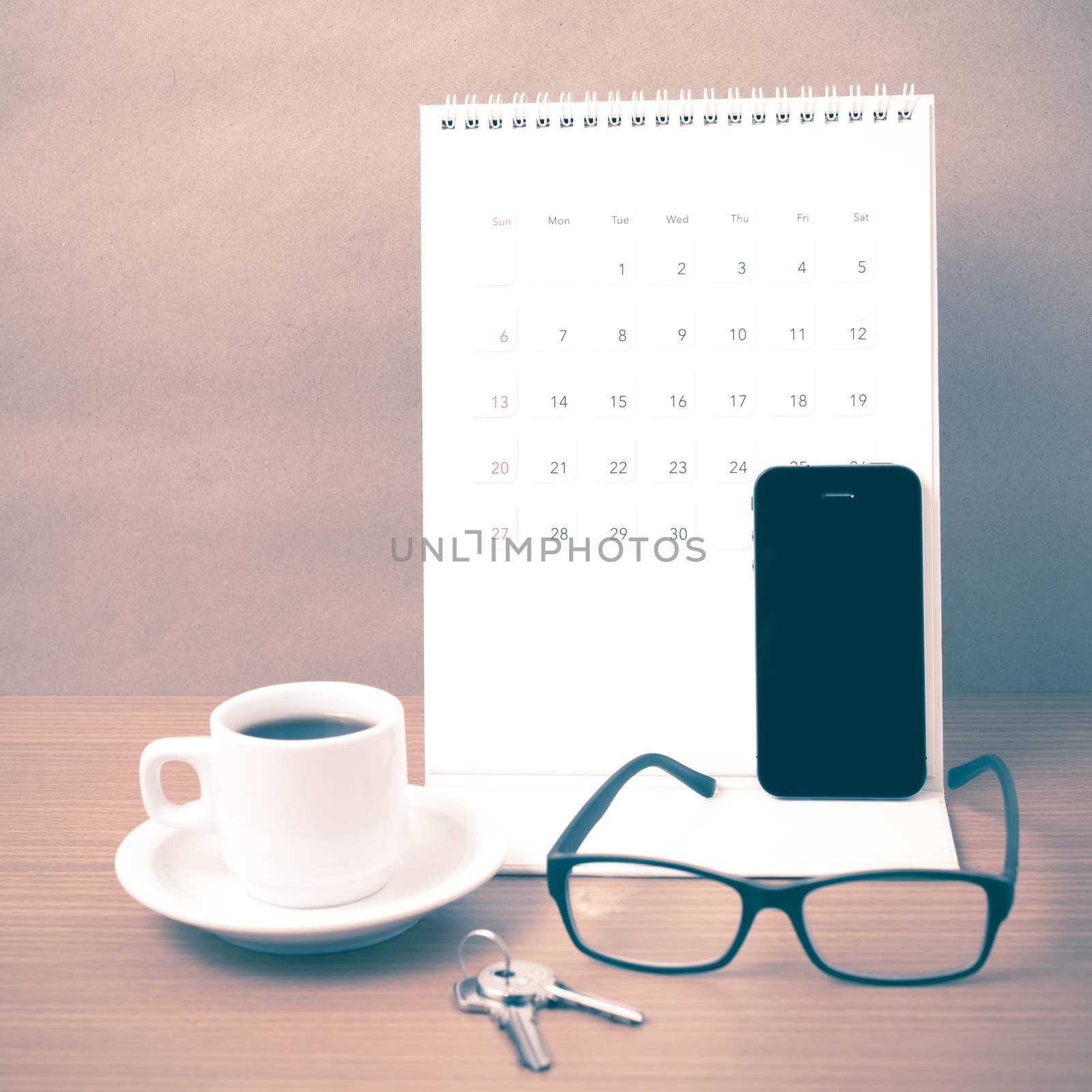 coffee,phone,eyeglasses,calendar and key on wood table background vintage style