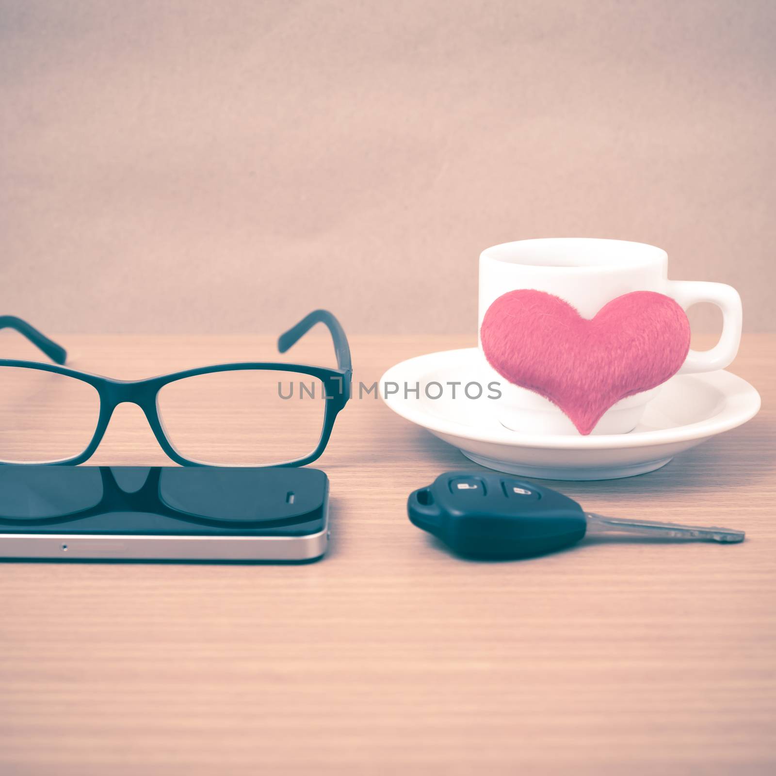 coffee,phone,eyeglasses and car key on wood table background vintage style