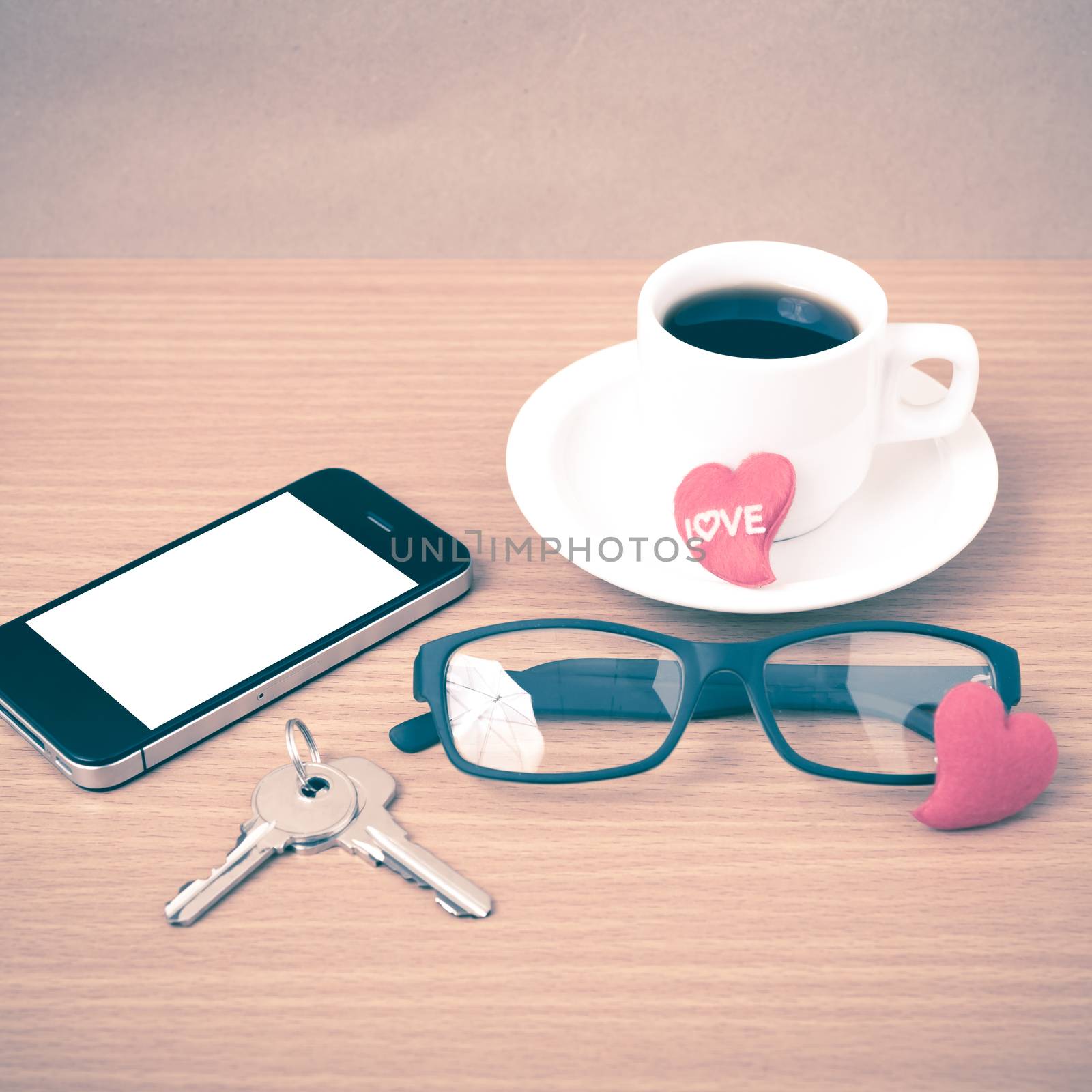 coffee,phone,eyeglasses and key on wood table background vintage style