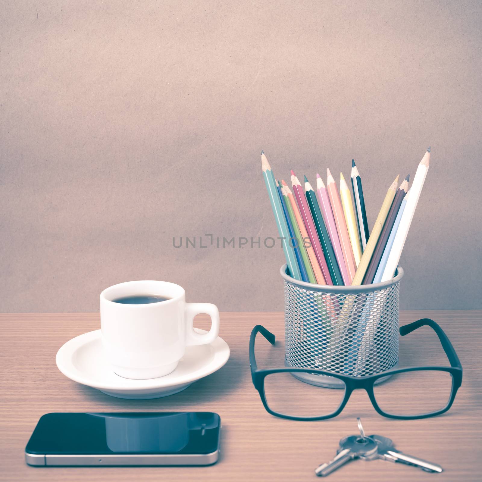 coffee,phone,eyeglasses,color pencil and key on wood table background vintage style