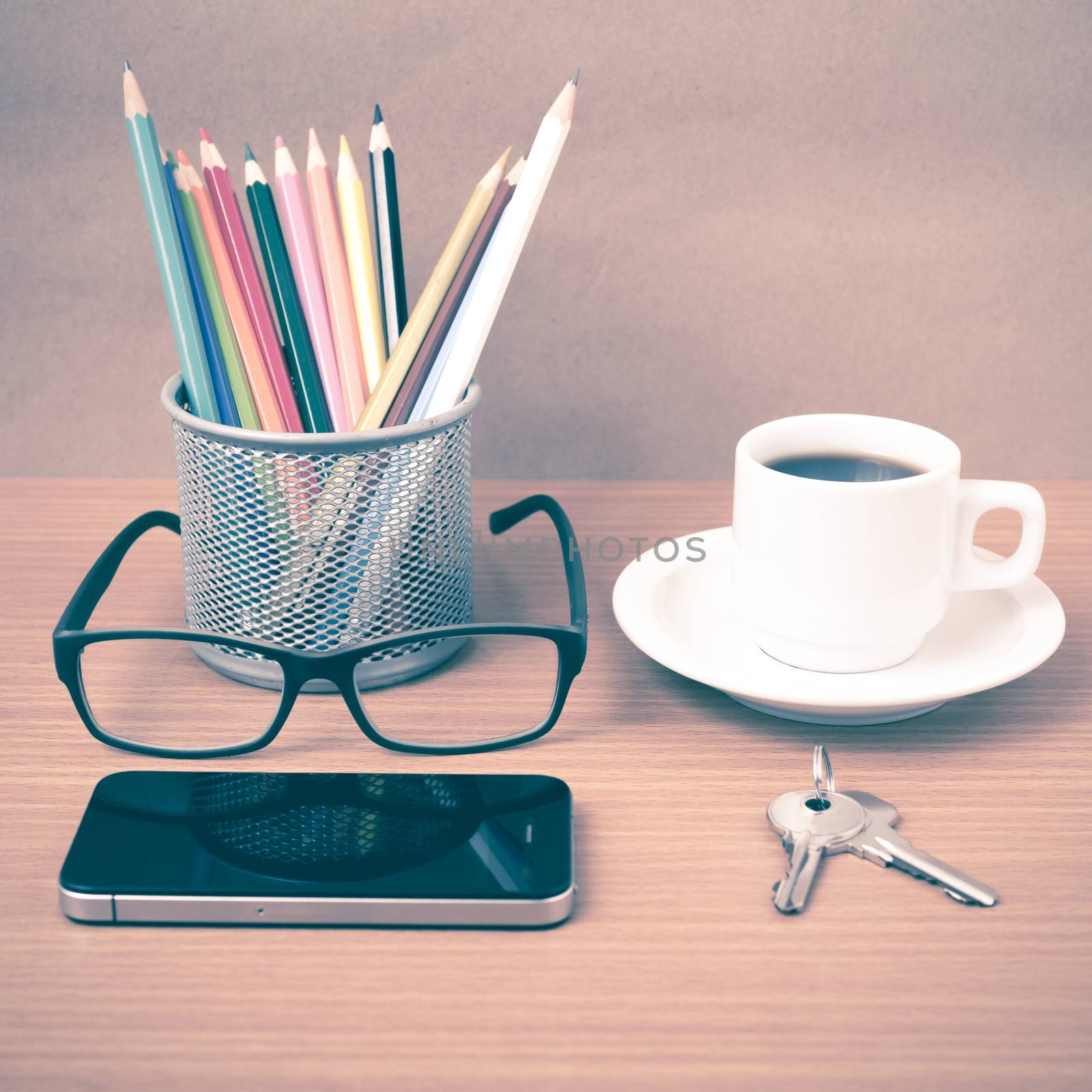 coffee,phone,eyeglasses,color pencil and key on wood table background vintage style