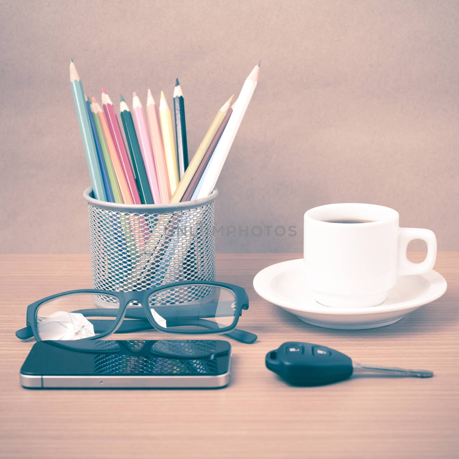 coffee,phone,eyeglasses,color pencil and car key on wood table background vintage style