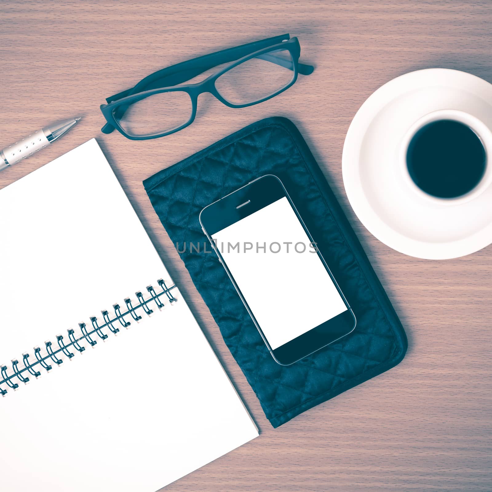 coffee,phone,eyeglasses,notepad and wallet on wood table background vintage style