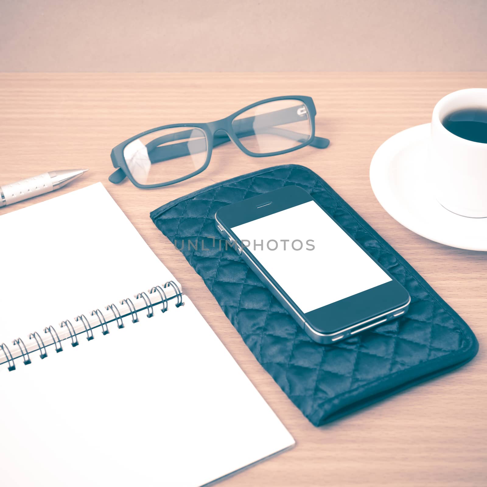 coffee,phone,eyeglasses,notepad and wallet on wood table background vintage style