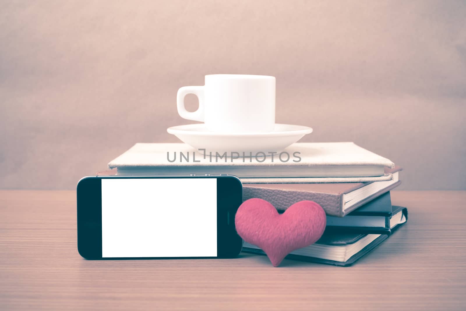 coffee,phone,stack of book and heart on wood table background vintage style