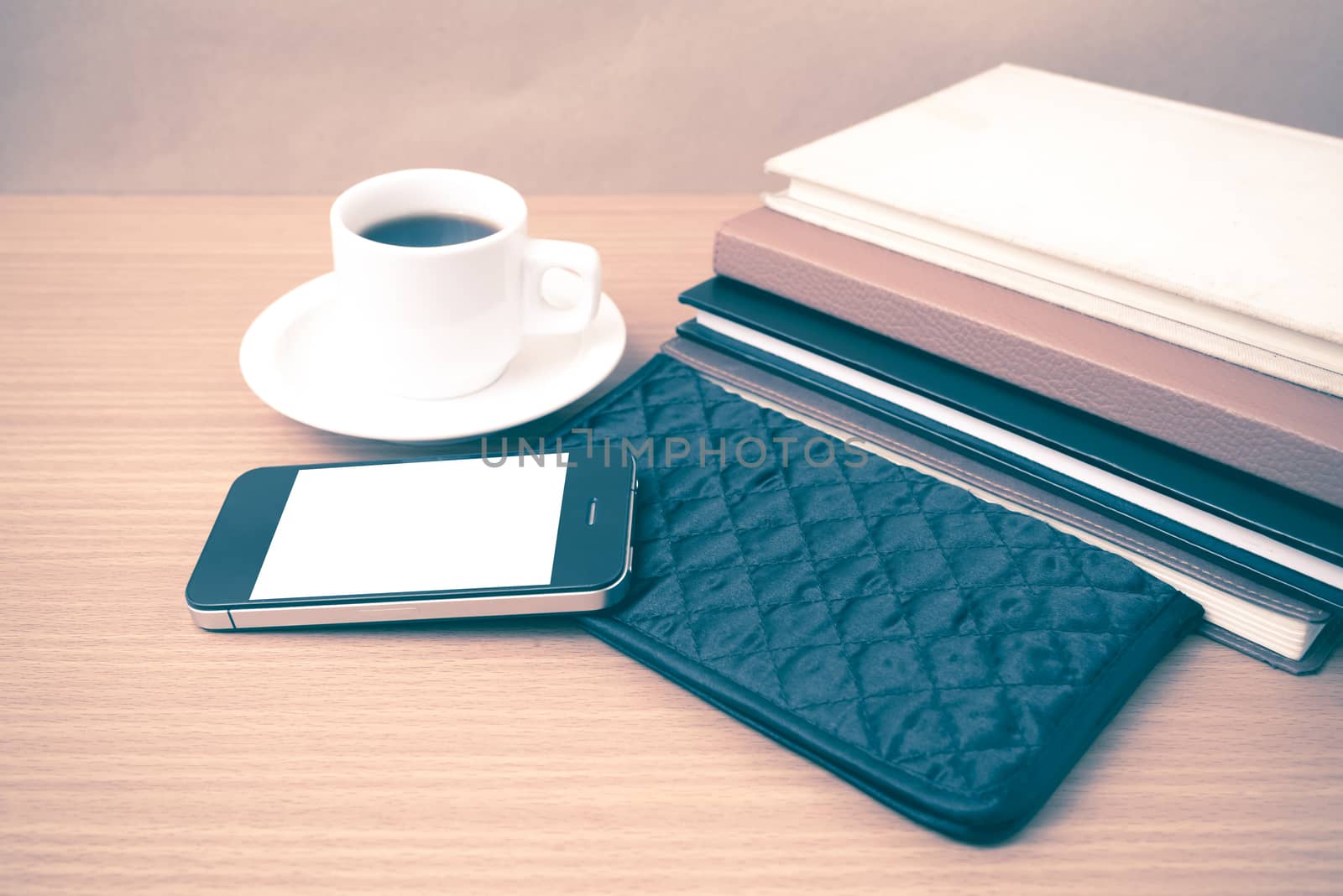 coffee,phone,stack of book and wallet on wood table background vintage style