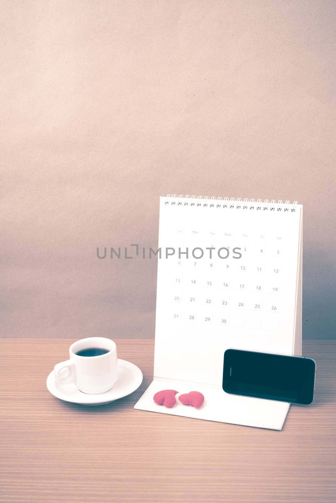 coffee,phone,calendar and heart on wood table background vintage style