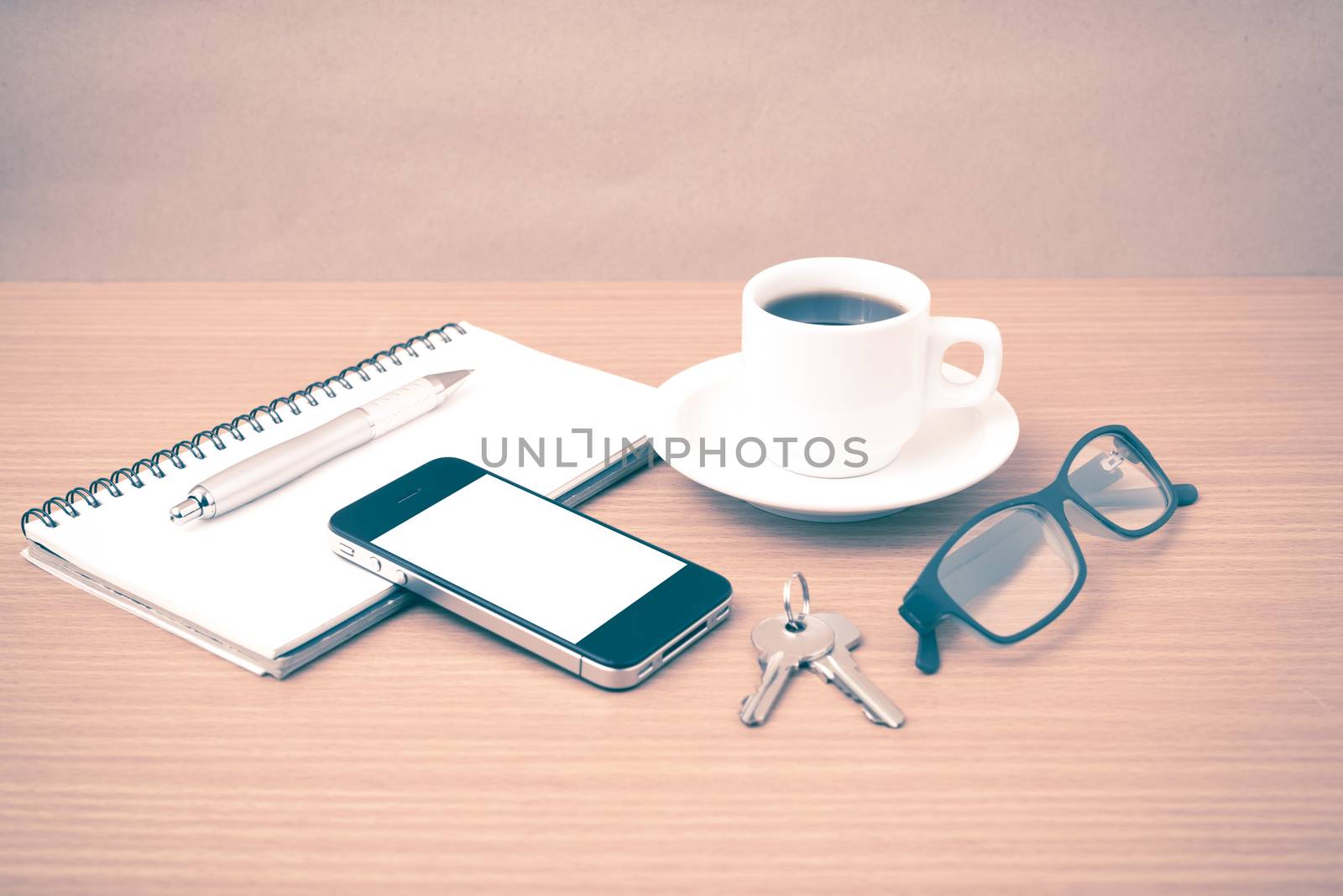 coffee,phone,notepad,eyeglasses and key on wood table background vintage style