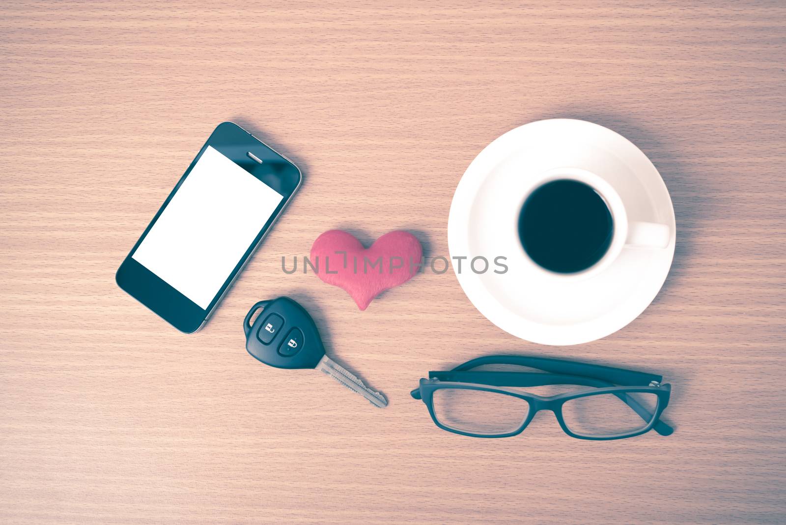 coffee,phone,eyeglasses and car key on wood table background vintage style