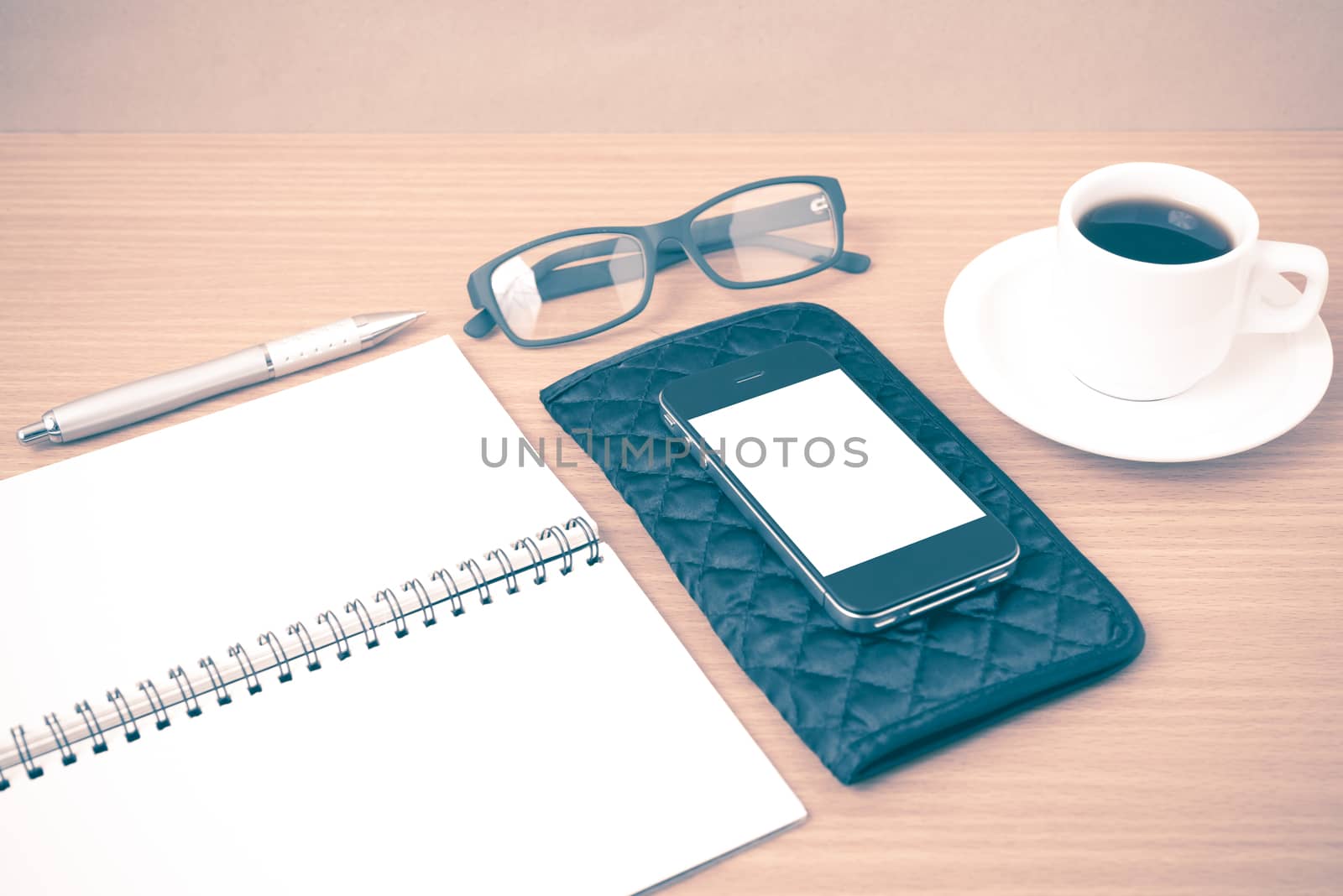 coffee,phone,eyeglasses,notepad and wallet on wood table background vintage style