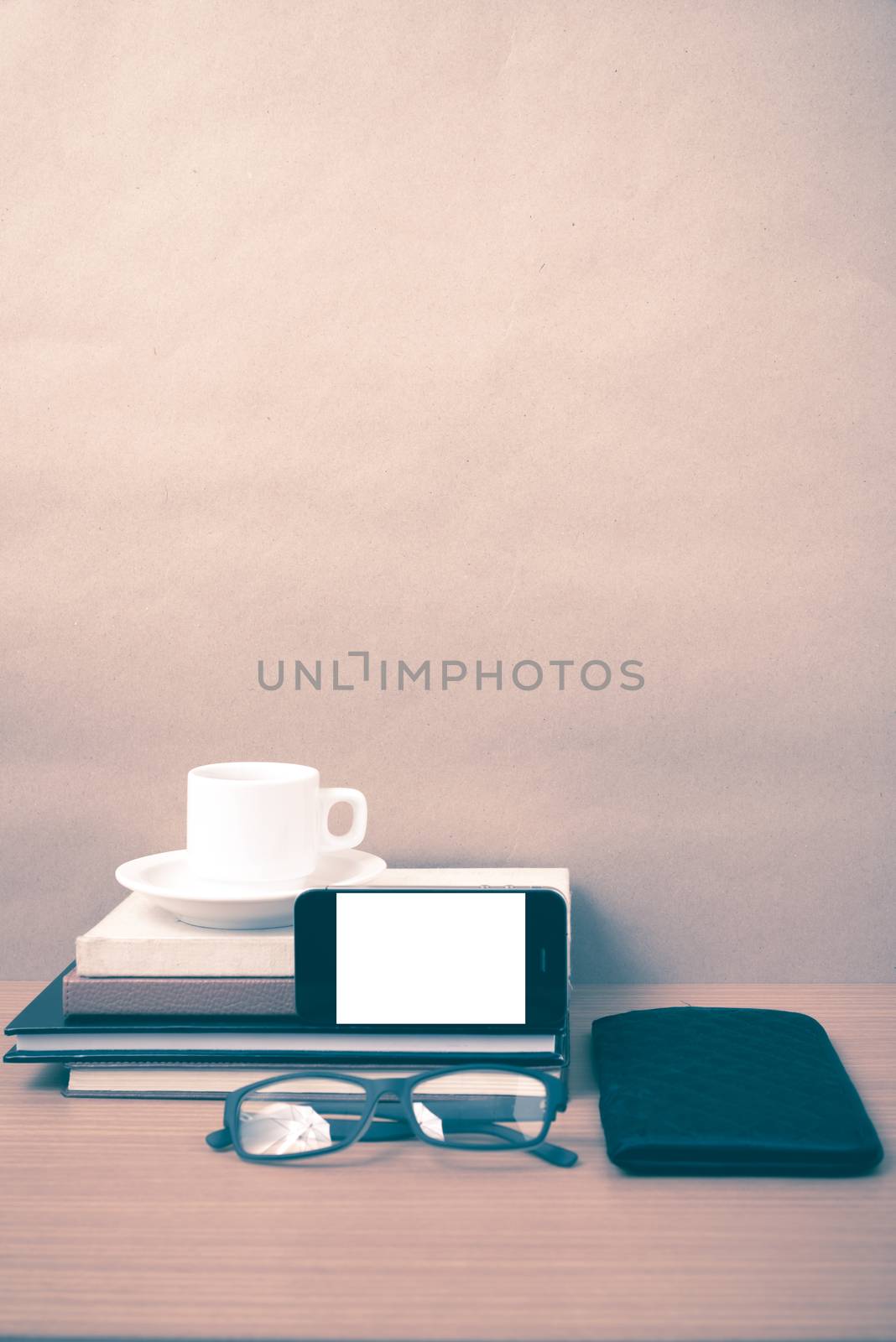 coffee,phone,eyeglasses,stack of book and wallet on wood table background vintage style