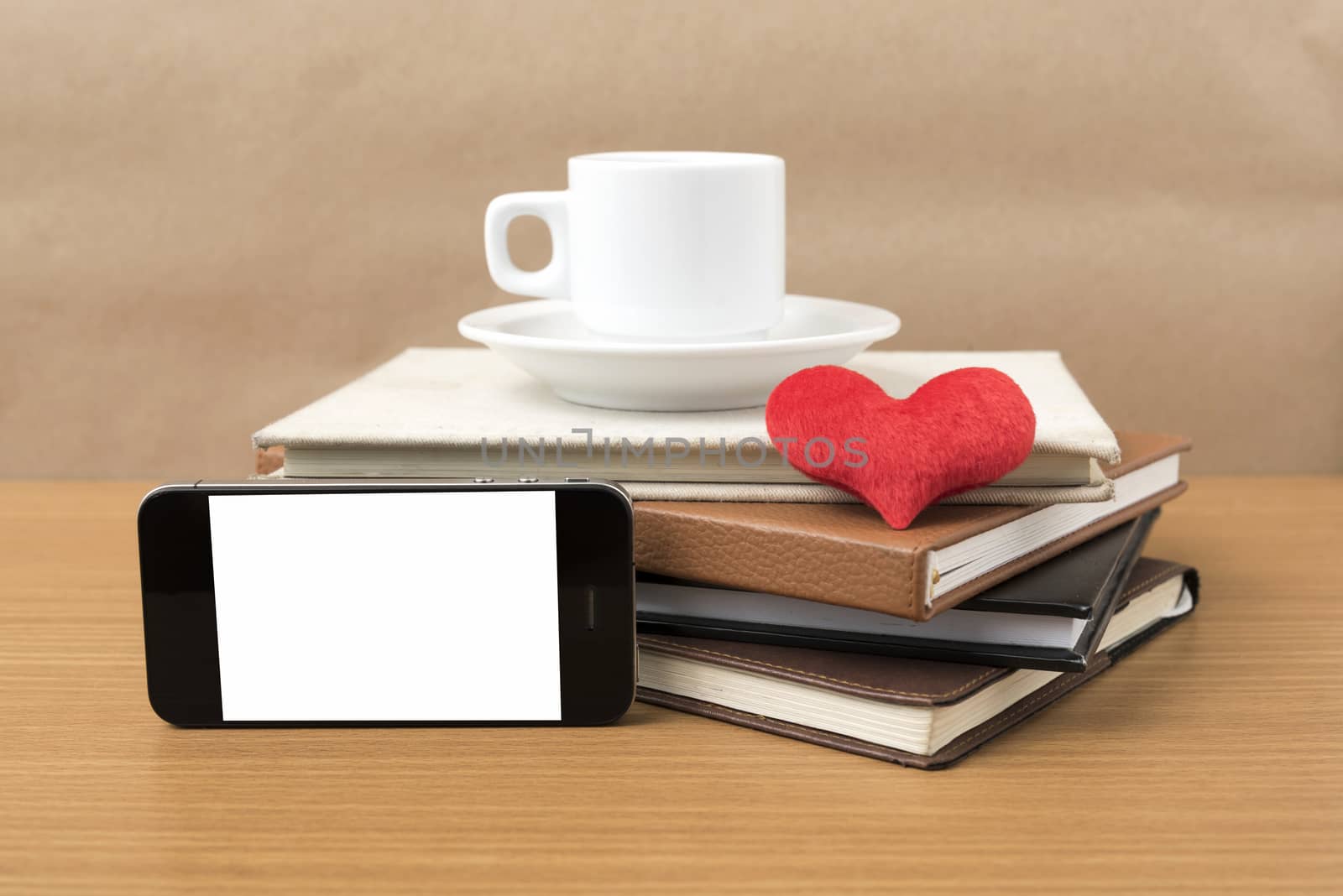 coffee,phone,stack of book and heart on wood table background