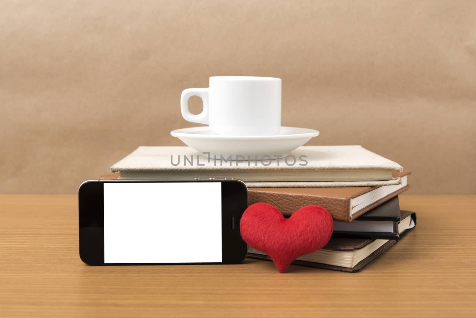 coffee,phone,stack of book and heart on wood table background