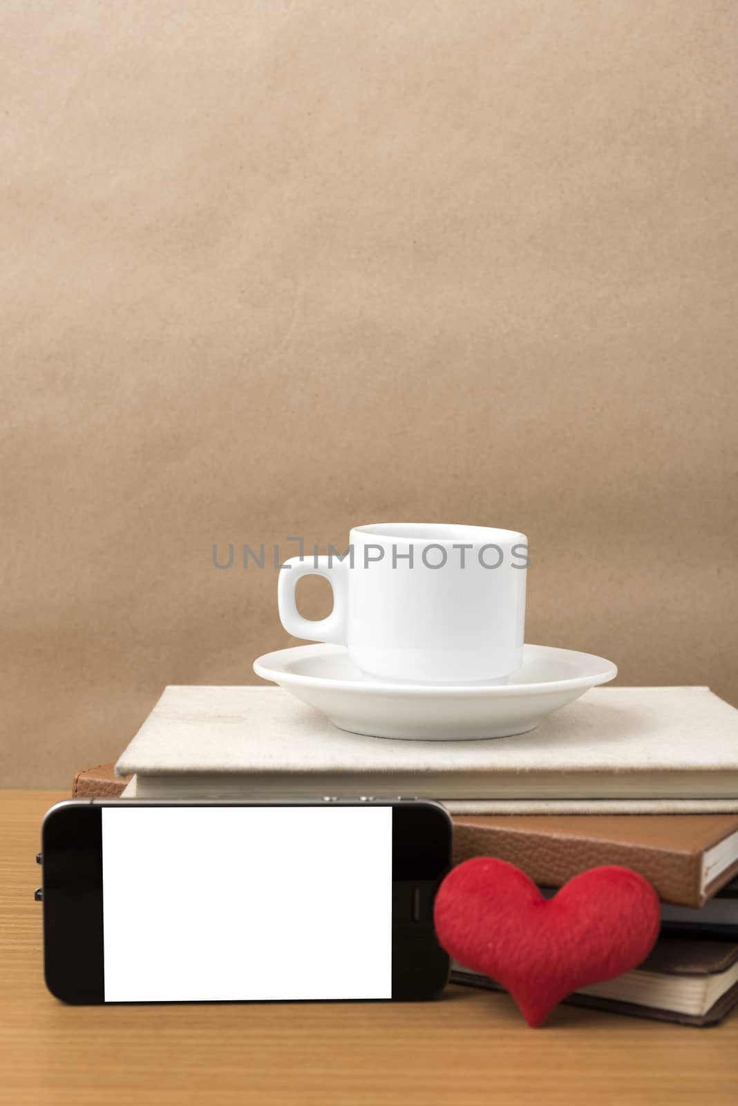 coffee,phone,stack of book and heart on wood table background