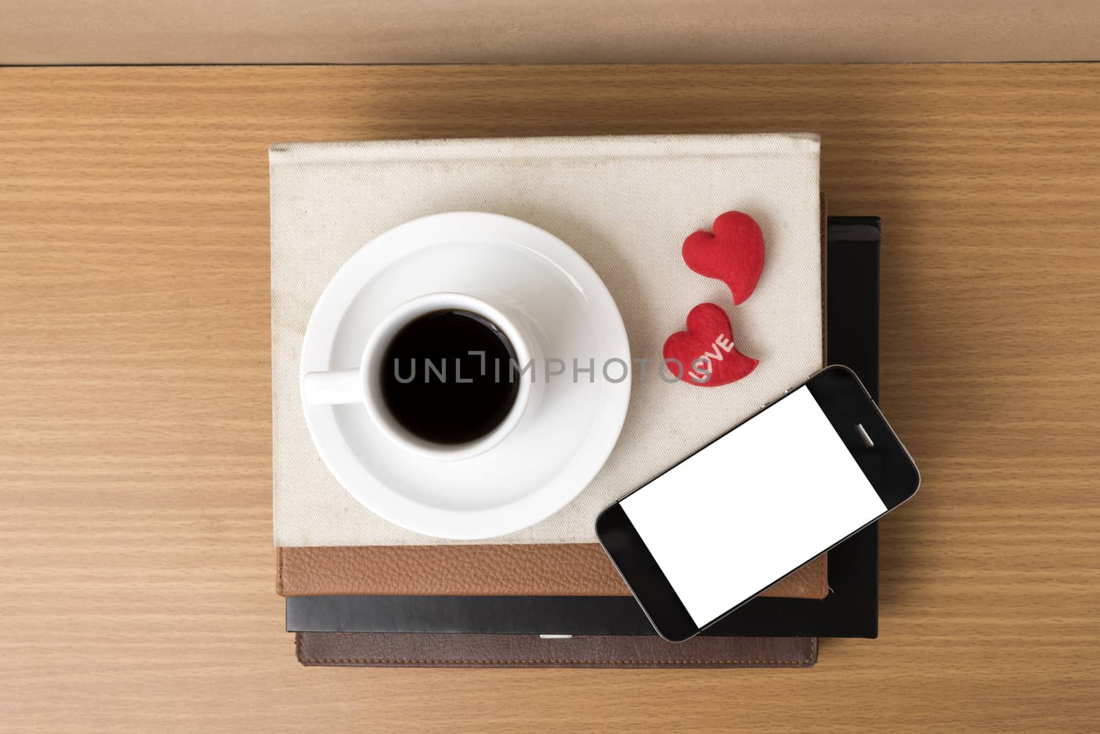 coffee,phone,stack of book and heart on wood table background