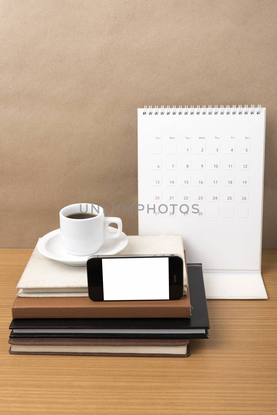 coffee,phone,stack of book and calendar on wood table background