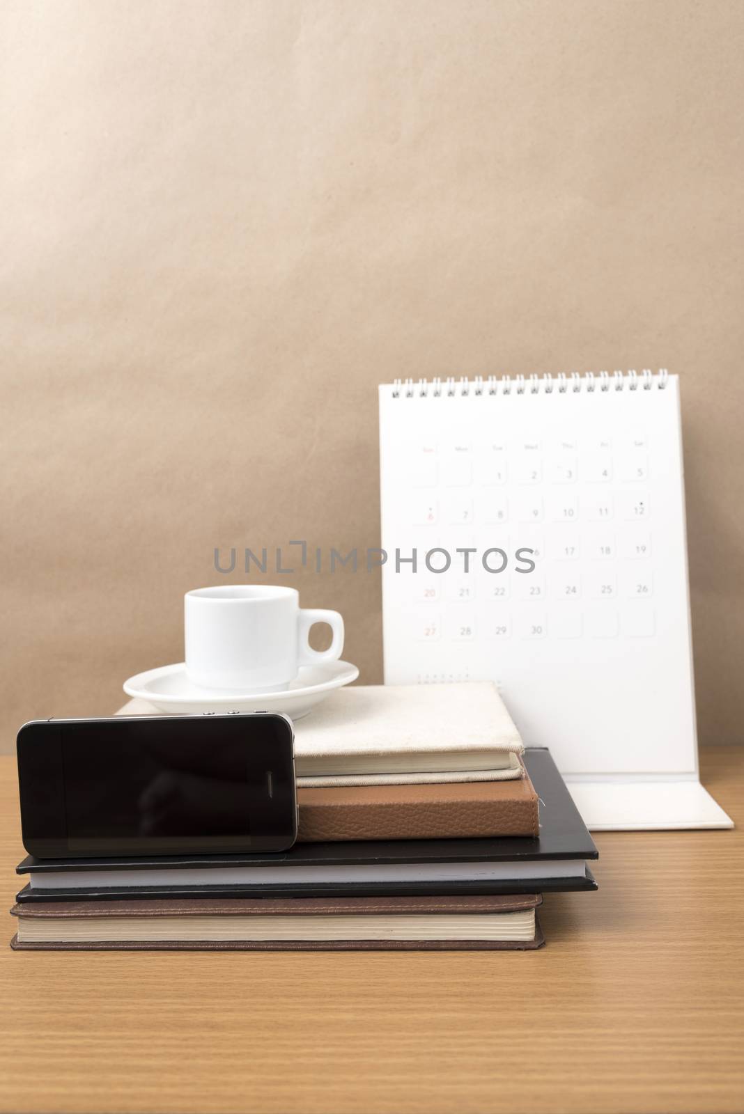 coffee,phone,stack of book and calendar on wood table background