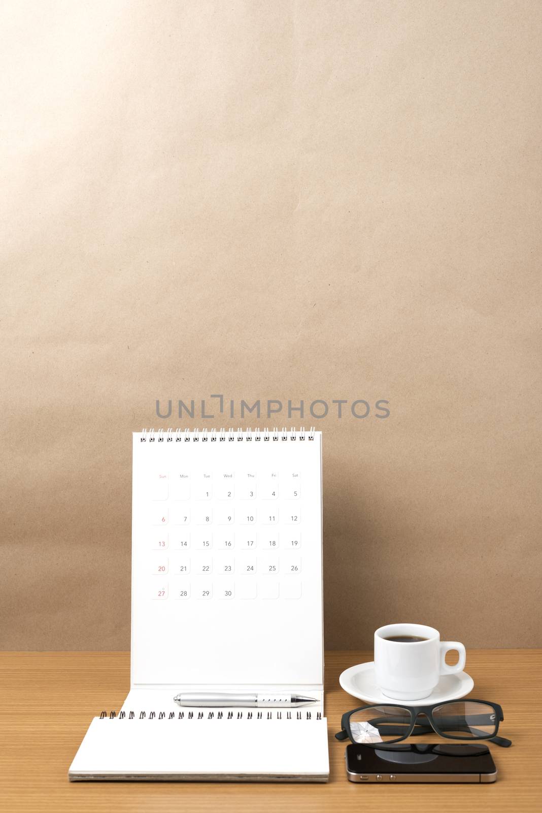 coffee,phone,eyeglasses,notepad and canlendar on wood table background